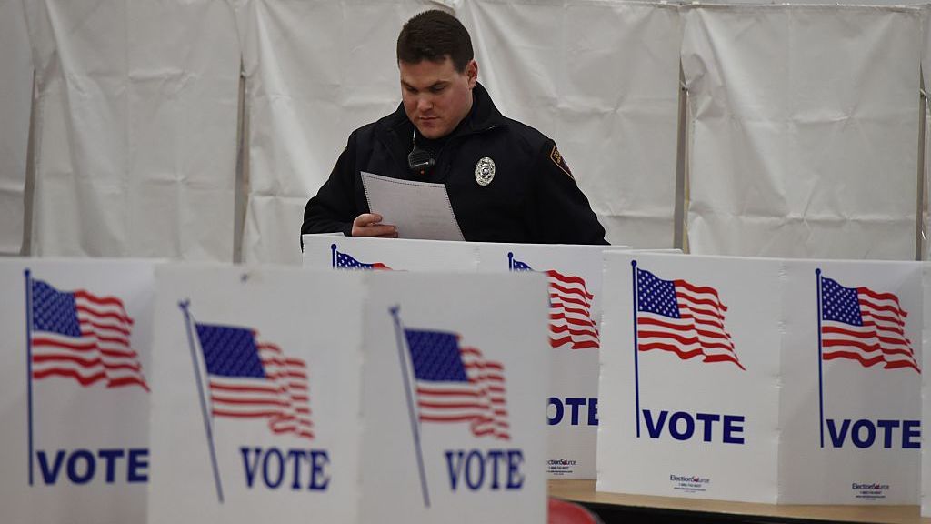 A police officer votes at Belmont High School on Feb. 9, 2016, in Belmont, N.H., during the New Hampshire presidential primary. The state's lawmakers are now debating bills that would tighten residency requirements for new voters. (AFP/Getty Images)