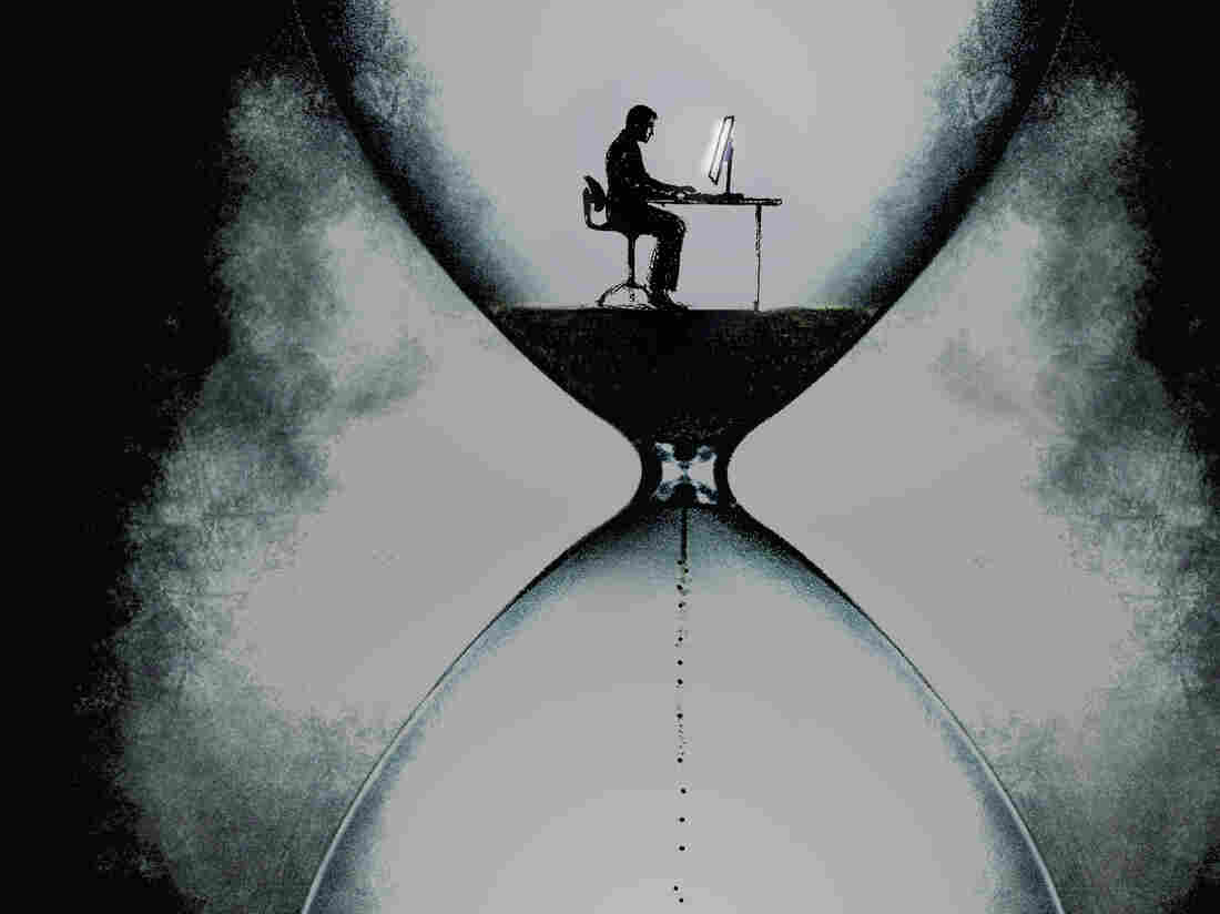 Businessman at desk in an hourglass.