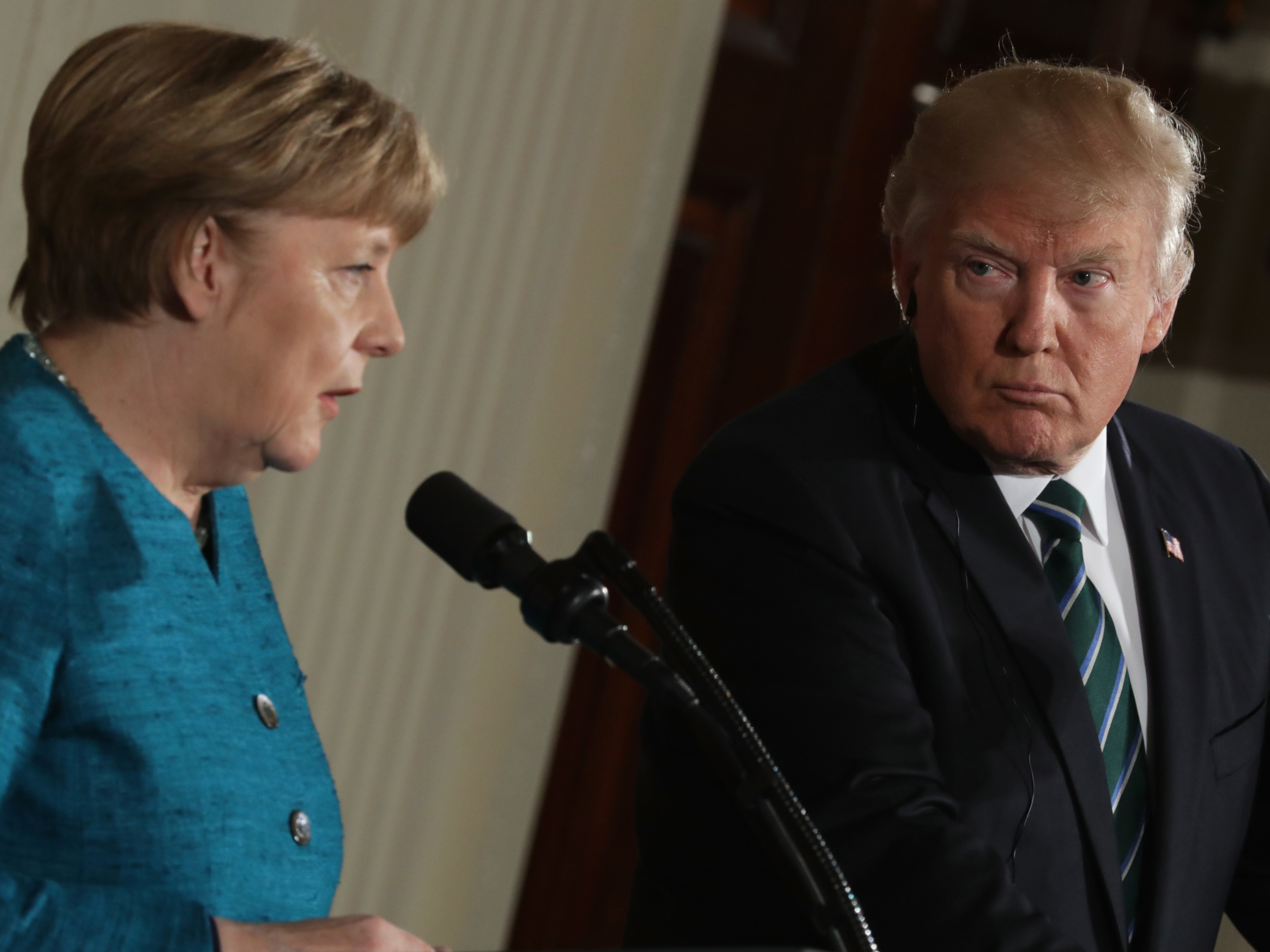 President Trump looks on as German Chancellor Angela Merkel addresses the media at a joint news conference Friday at the White House. (Getty Images)