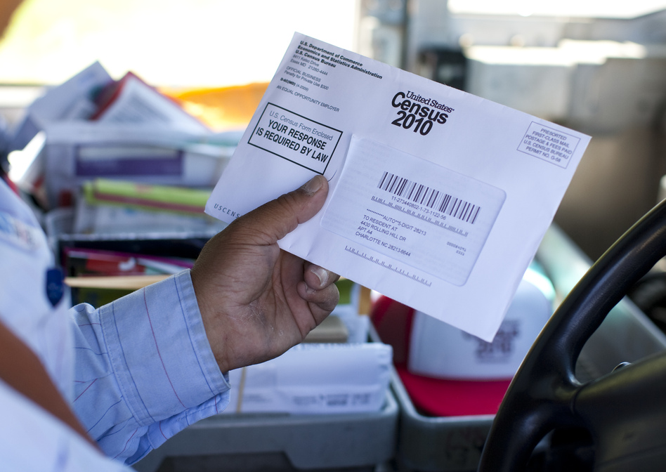 U.S. Postal Service mail carrier Thomas Russell holds a census form while working his route in 2010. (Jason E. Miczek/AP)