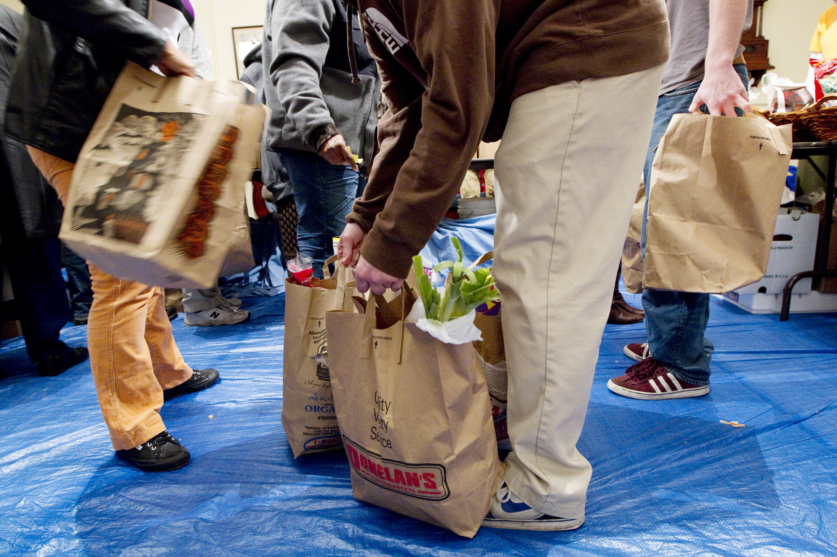 Volunteers gather bags of groceries for people seeking assistance at a food pantry in Concord, Mass. Many groups that help low-income families get food aid say they've seen an alarming drop recently in the number of immigrants applying for help. (Yoon S. Byun/Boston Globe/Getty Images)