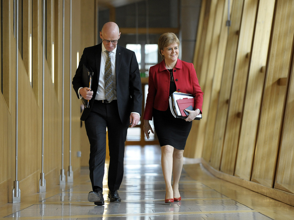 Scottish First Minister Nicola Sturgeon and Deputy First Minister John Swinney arrive at Scottish Parliament on Tuesday. They attended the second day of debate on a motion that ultimately granted Sturgeon the authority to pursue an independence referendum. (Andy Buchanan/AFP/Getty Images)
