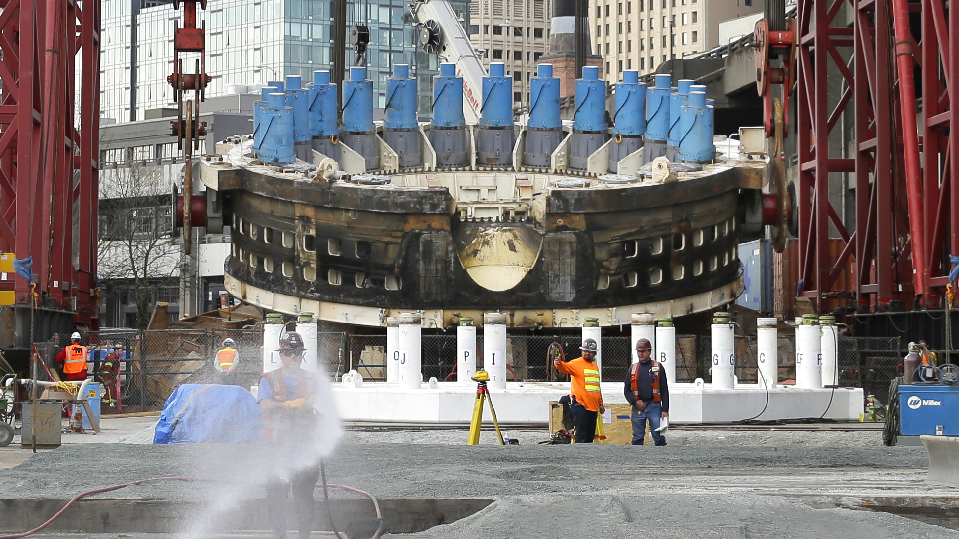 Workers prepare a gravel pad as a massive crane is used to lift a 2,000-ton section of the tunnel boring machine known as "Bertha" in March 2015. The project was stalled for two years as engineers struggled to repair the gigantic machine. (AP)