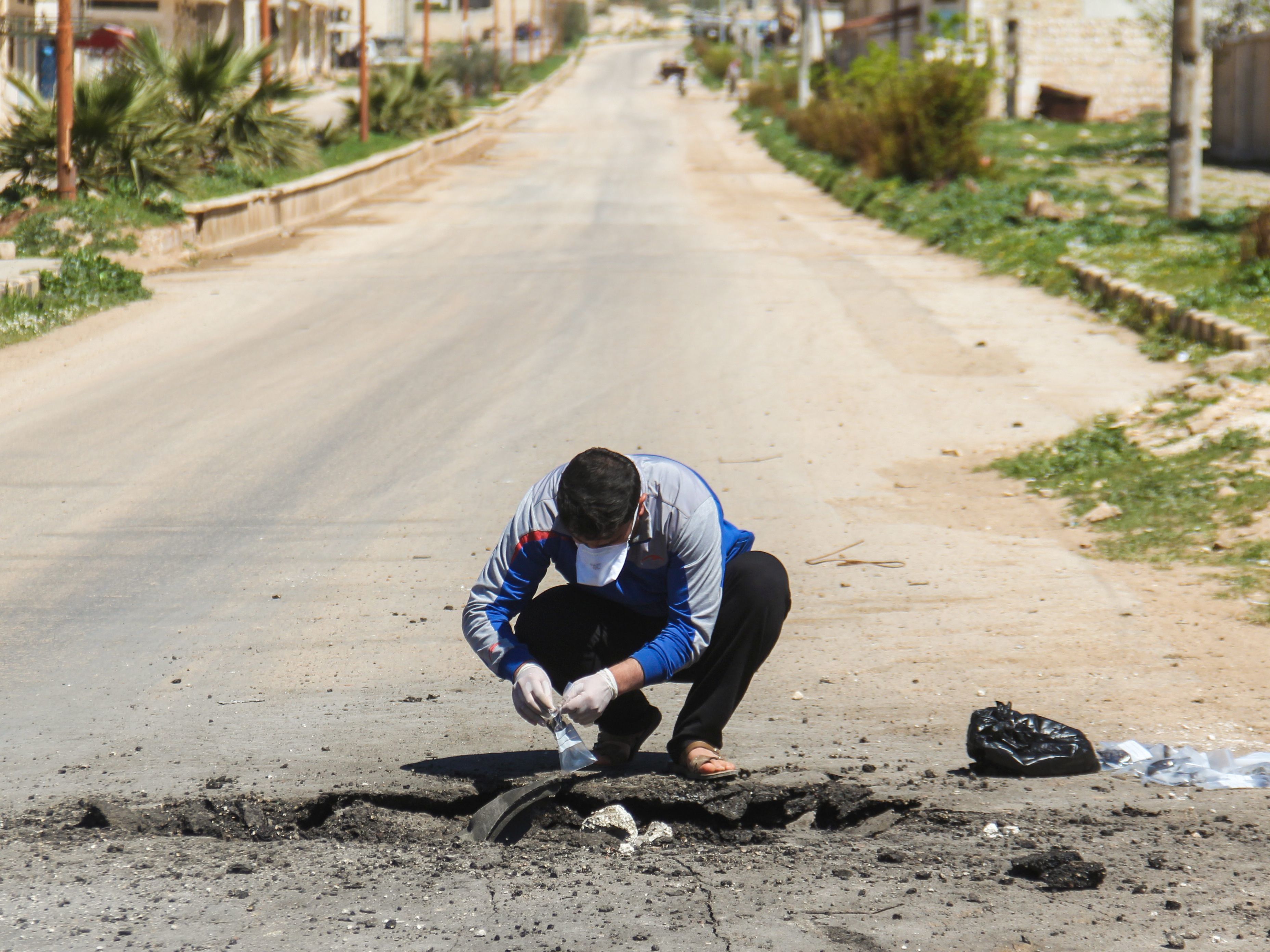 A man collects samples Wednesday from the site of a suspected toxic chemicals attack in Khan Shaykhun the day before. (Omar Haj Kadour/AFP/Getty Images)