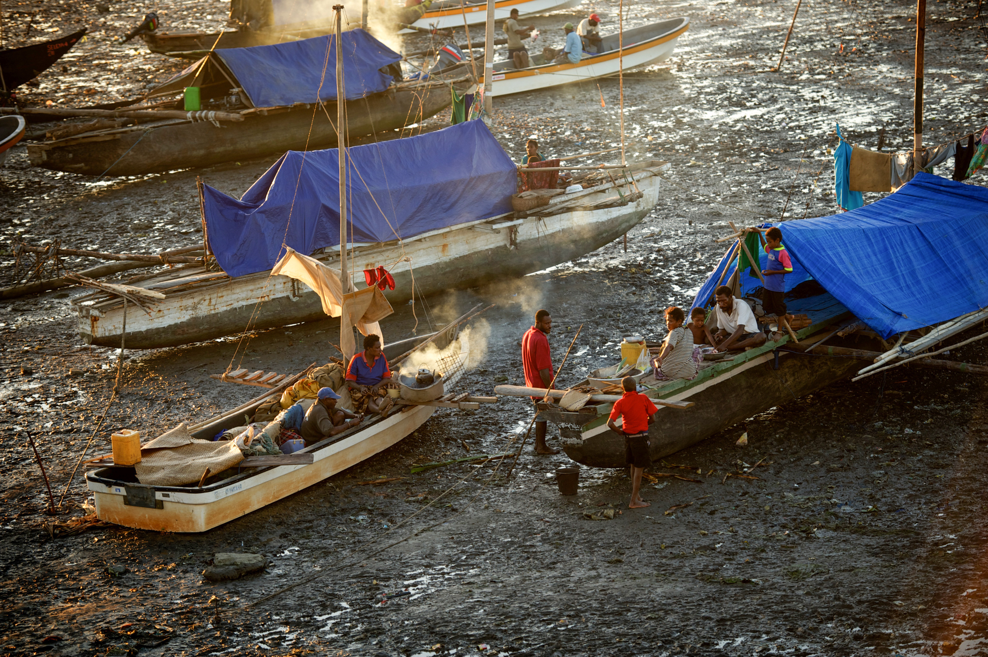 Fishermen in Papua New Guinea, living on their boats, wait for the tide to change before going out to fish. Tuberculosis is a major health threat in the Pacific Ocean nation.