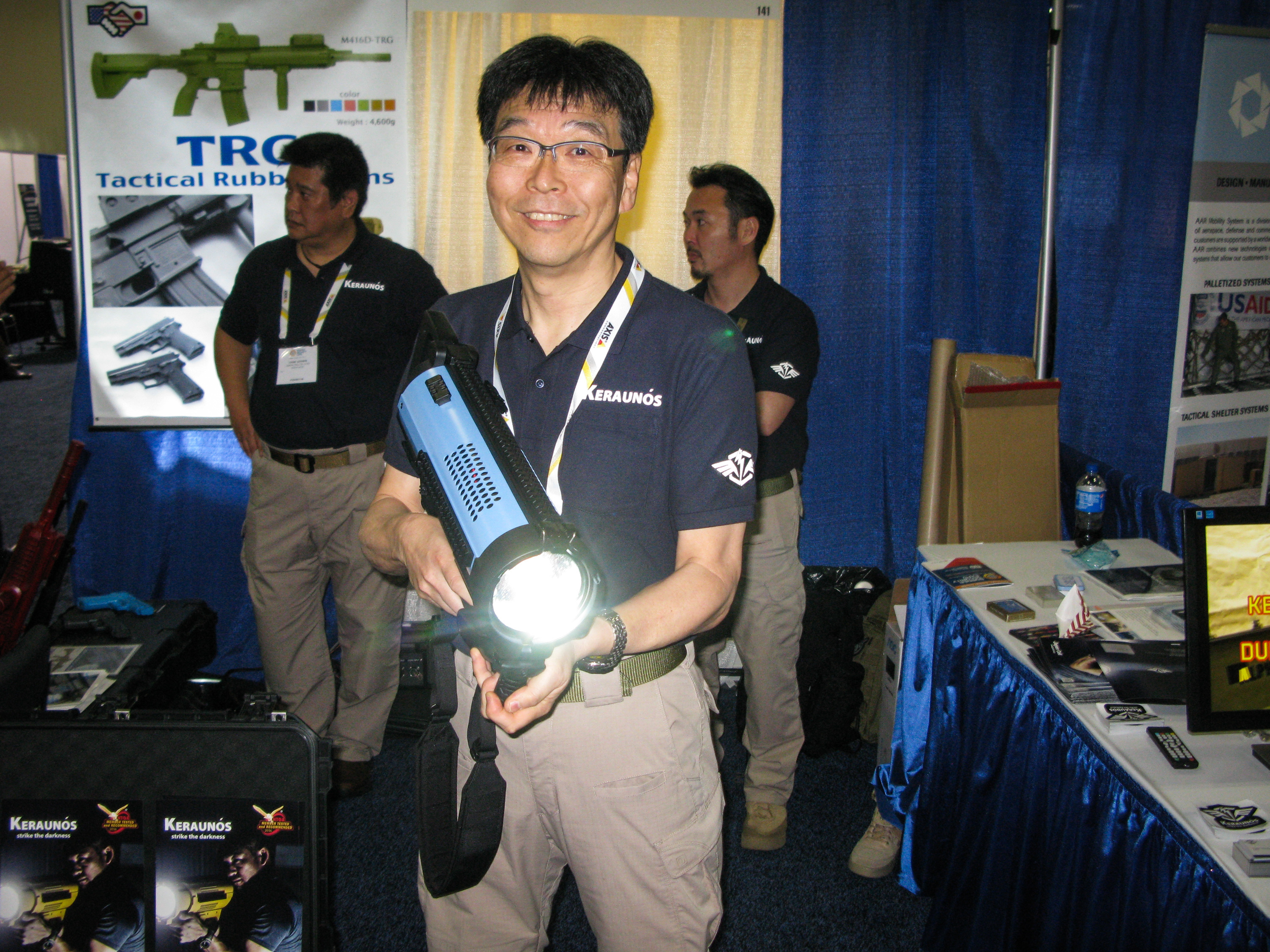 Hiro Yazawa of Japan Cell displays a spotlight weapon that sells for $5,000 at the Border Security Expo in San Antonio on Tuesday. (NPR)