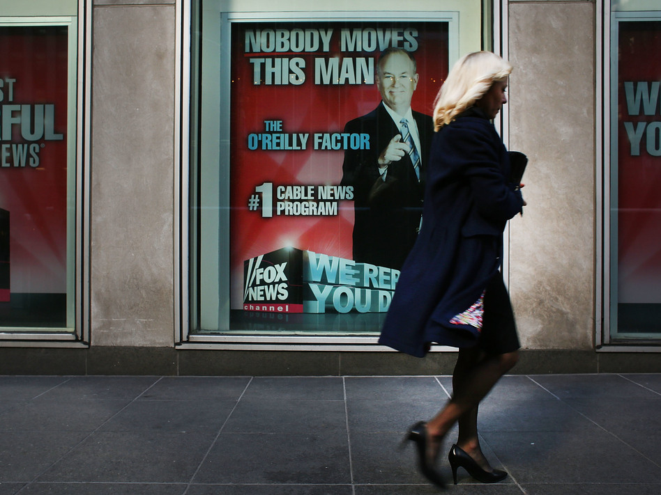 An ad for Bill O'Reilly's top-rated Fox News show stares back at passersby outside the News Corp. headquarters in New York City earlier this month. O'Reilly is stepping away from the show for a vacation as controversy continues to mount around sexual harassment claims. (Spencer Platt/Getty Images)