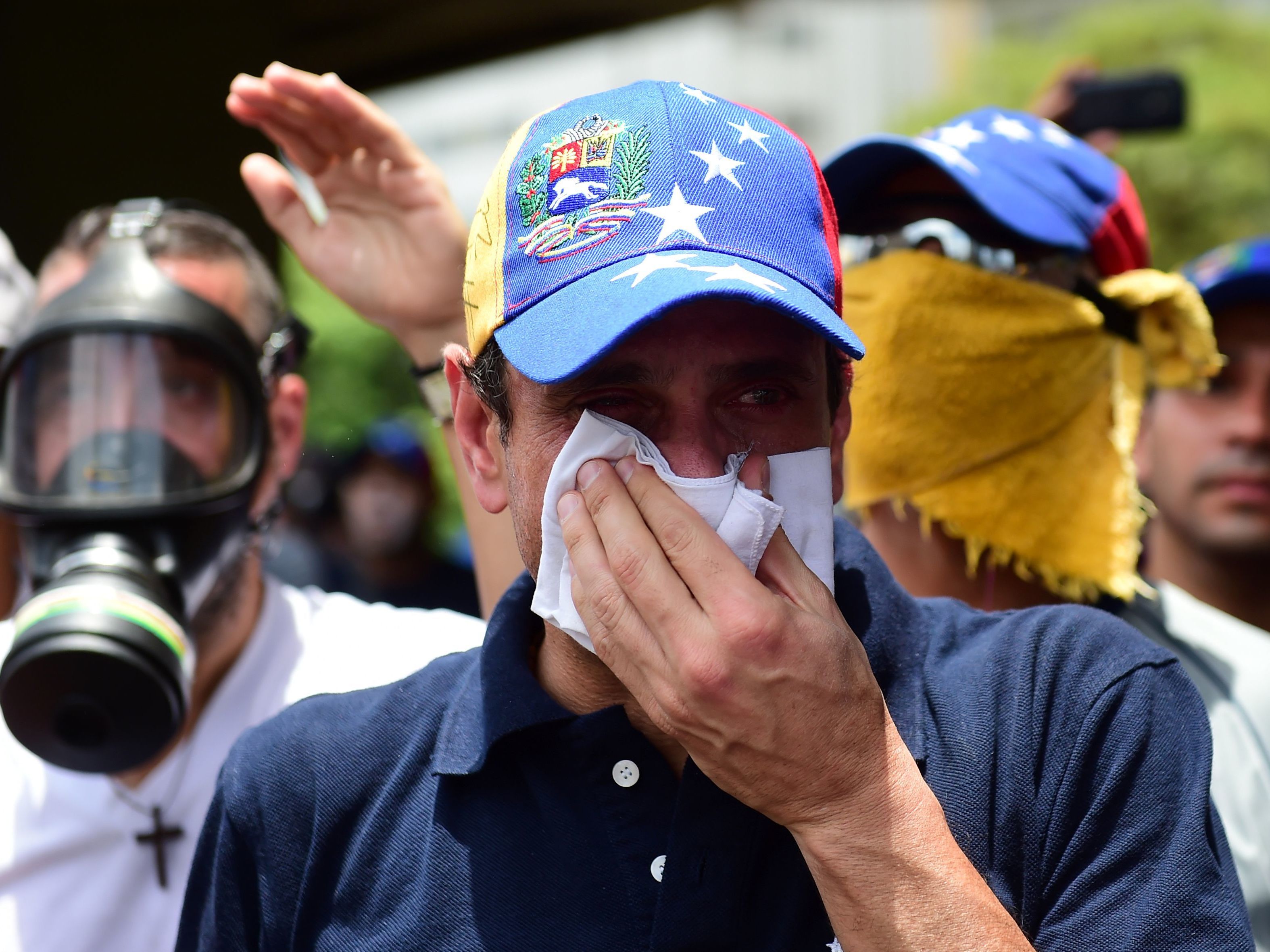 Opposition leader Henrique Capriles, who was banned from public office for 15 years, protects himself against tear gas during a rally against Venezuelan President Nicolas Maduro on Wednesday.
(Ronaldo Schemidt/AFP/Getty Images)