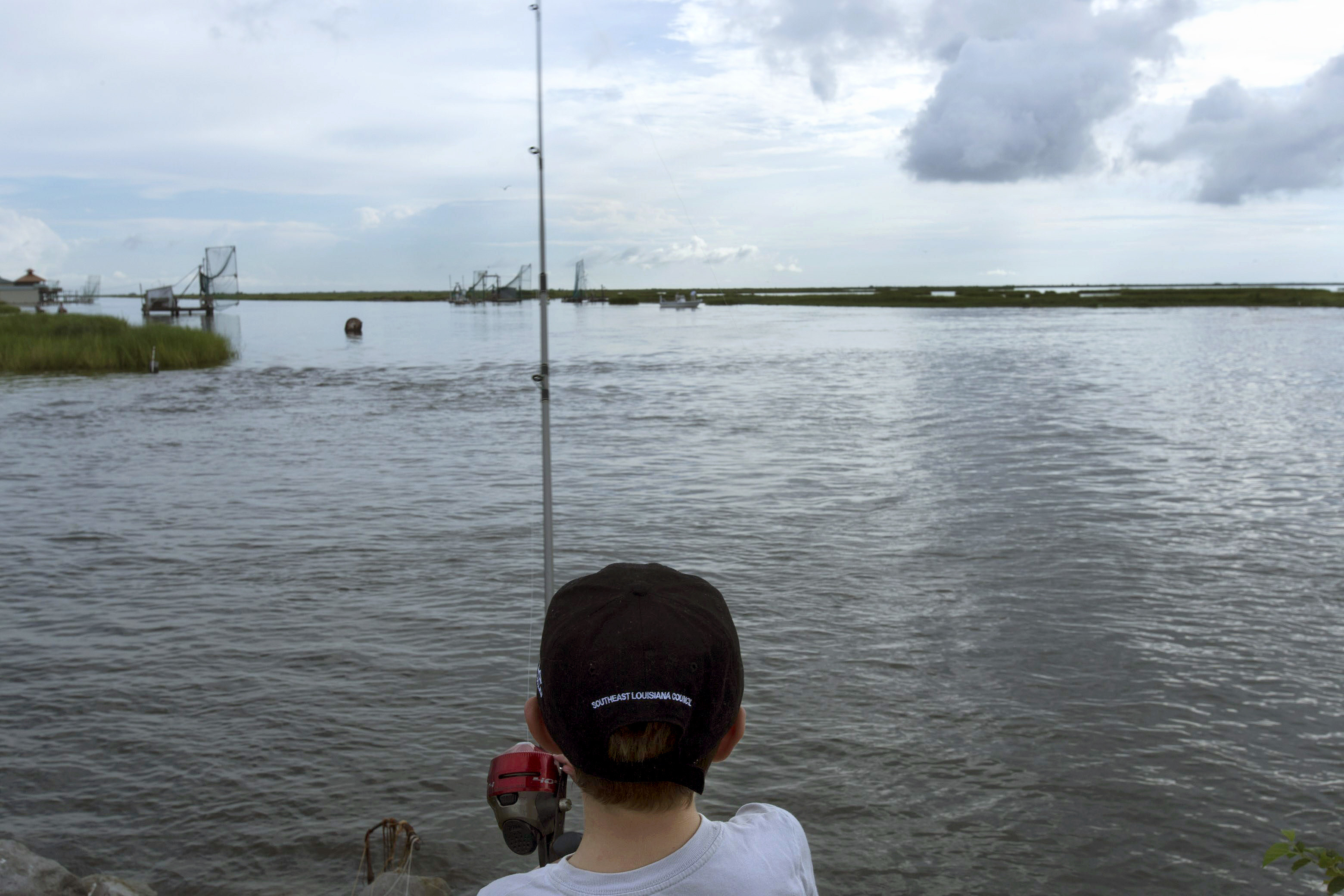 A boy fishes on a bayou near Isle de Jean Charles, La., in August 2015. Louisiana is still losing about a football field of coastline every hour. (AFP/Getty Images)