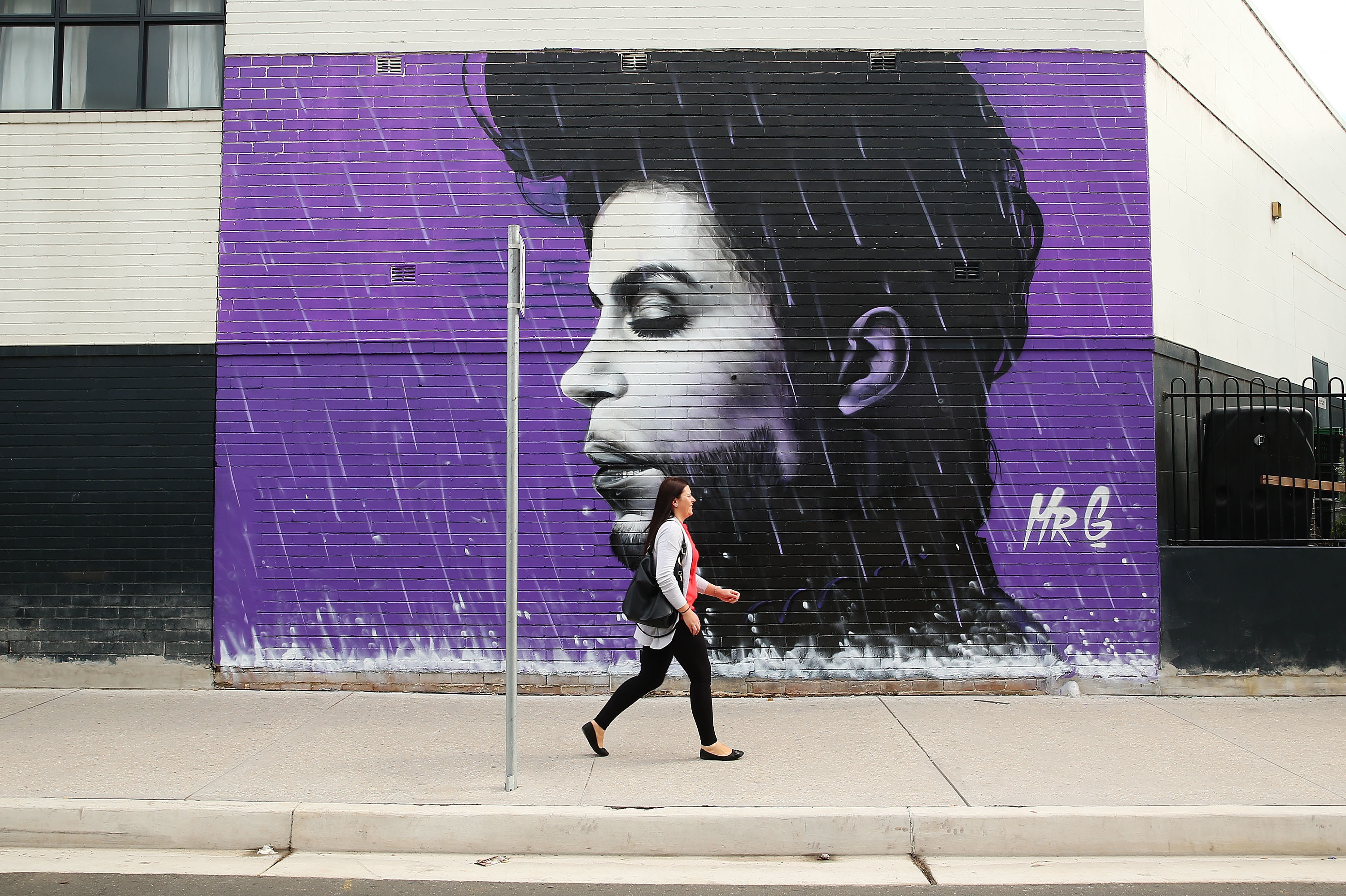 In The Wake Of Prince's Death 7 A woman walks past a mural of Prince on April 28, 2016 in Sydney, Australia.