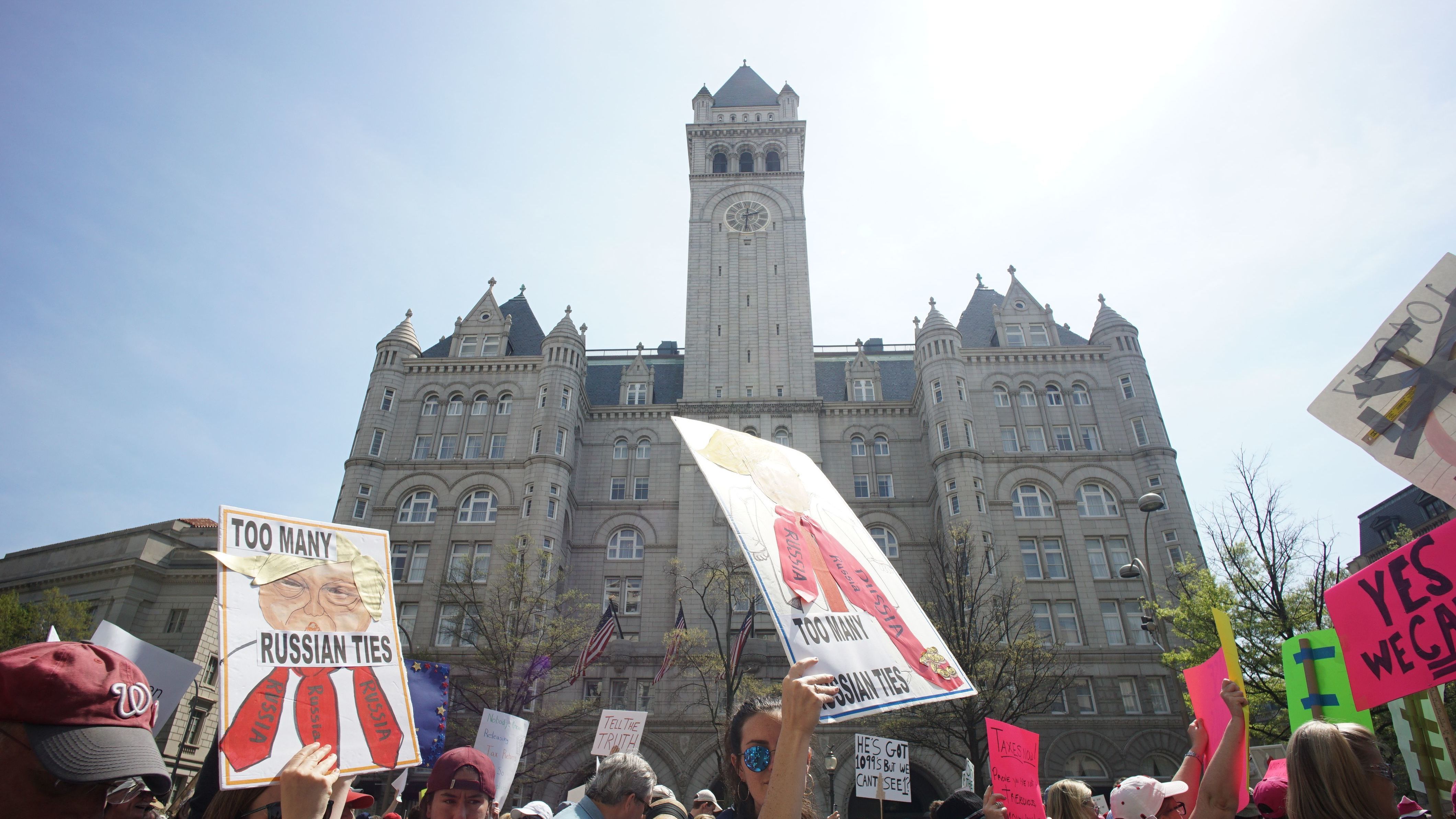 Protestors demonstrating April 15 against President Trump's purported ties to foreign governments walk by the Trump hotel during in Washington, D.C. (AFP/Getty Images)