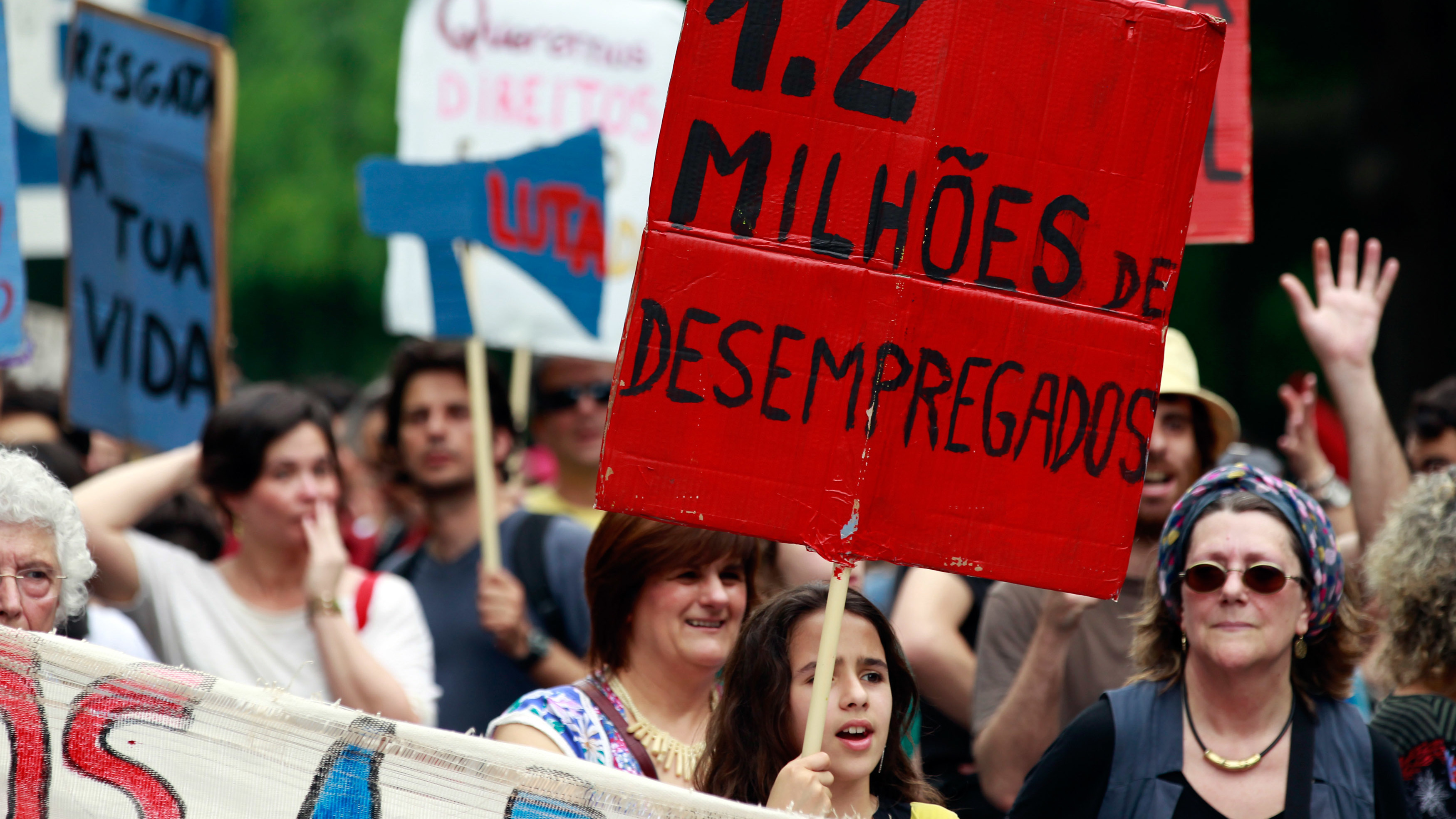 A young girl holds a sign with the words "1.2 Million Unemployed" during an anti-austerity protest in Lisbon on May 12, 2012.