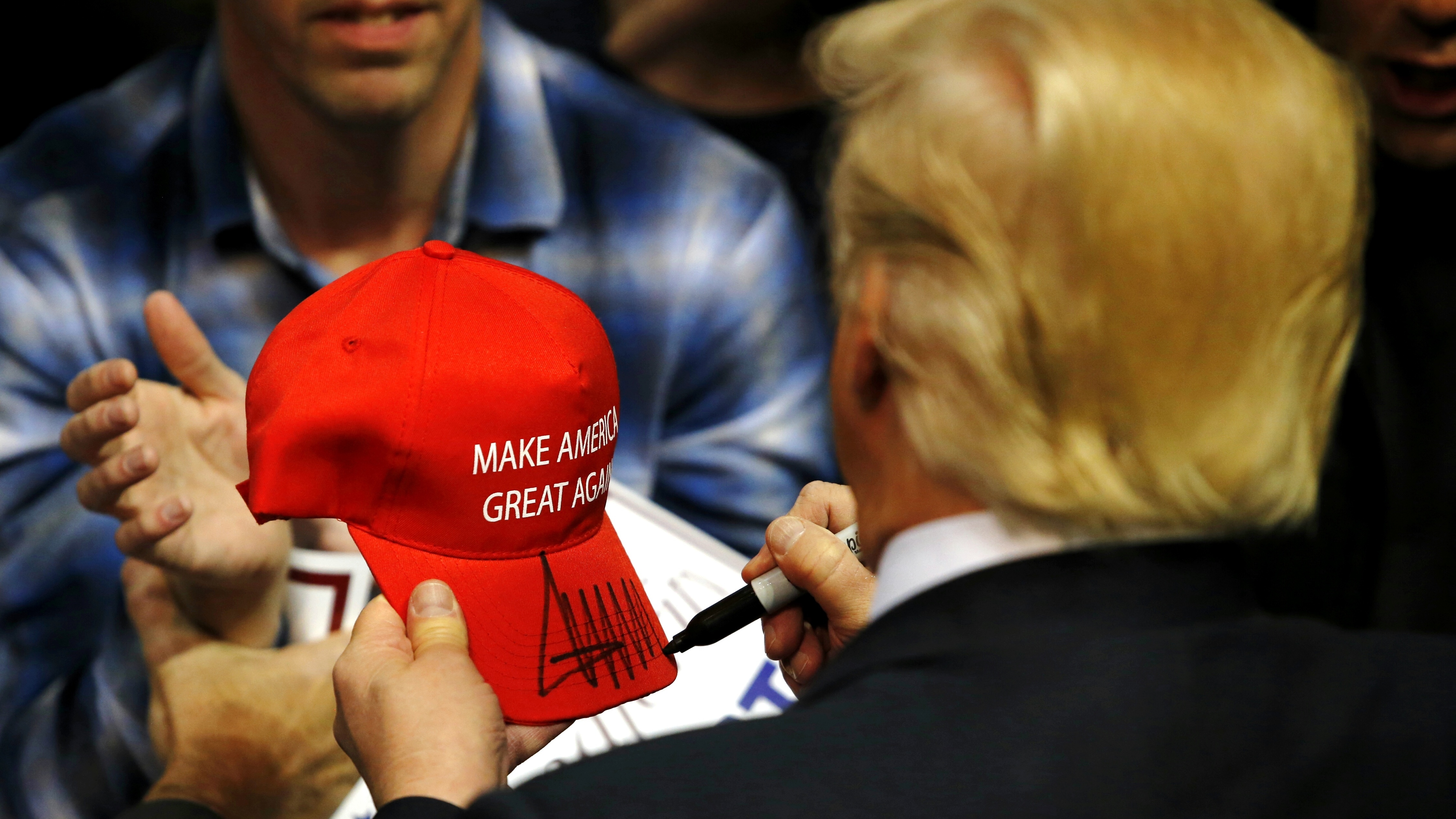 Republican presidential candidate Donald Trump signs a hat for a supporter after speaking at a campaign rally on April 11, 2016 in Albany, N.Y.