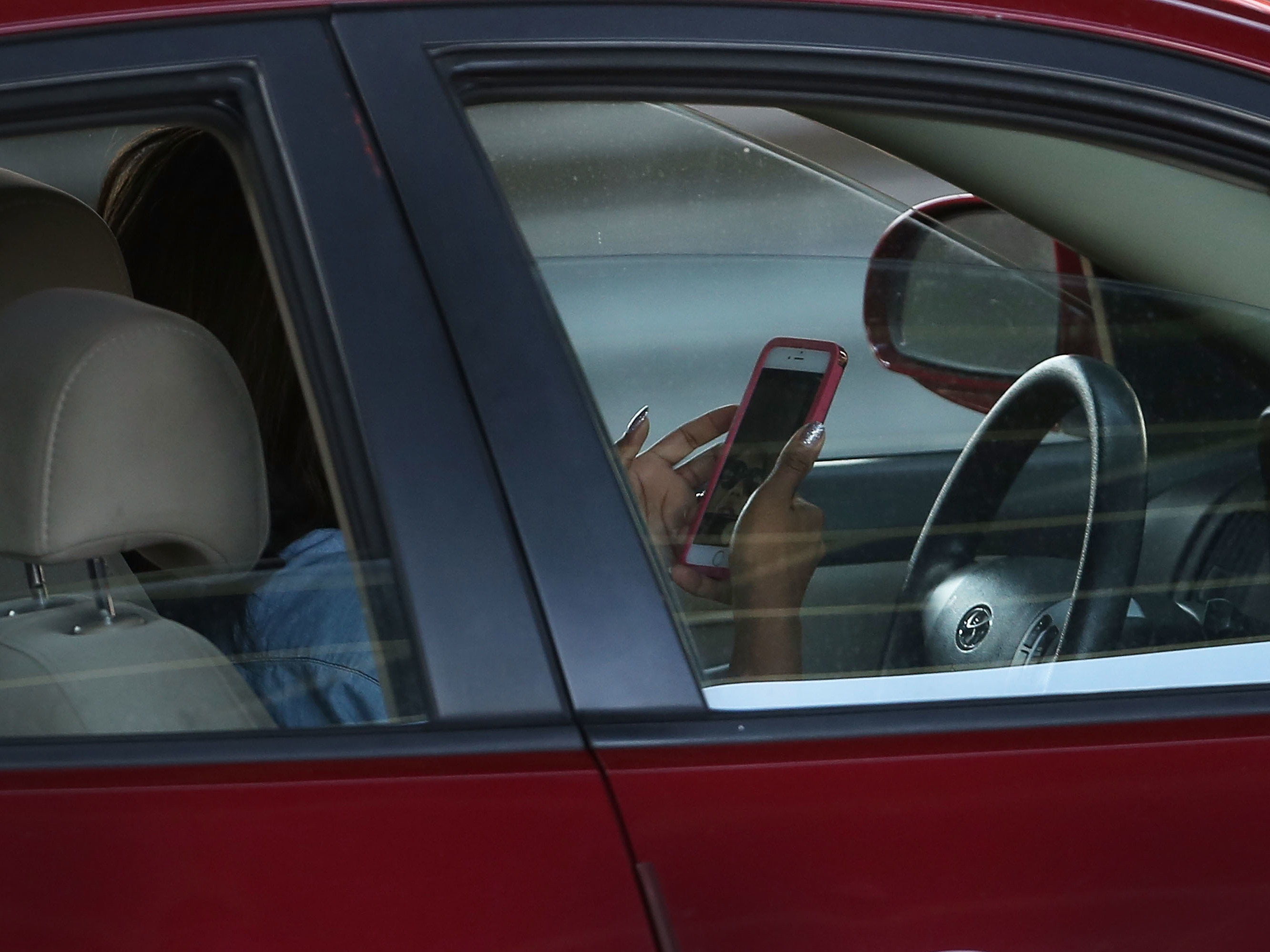 A driver uses a phone while behind the wheel of a car on April 30, 2016, in New York City. (Getty Images)
