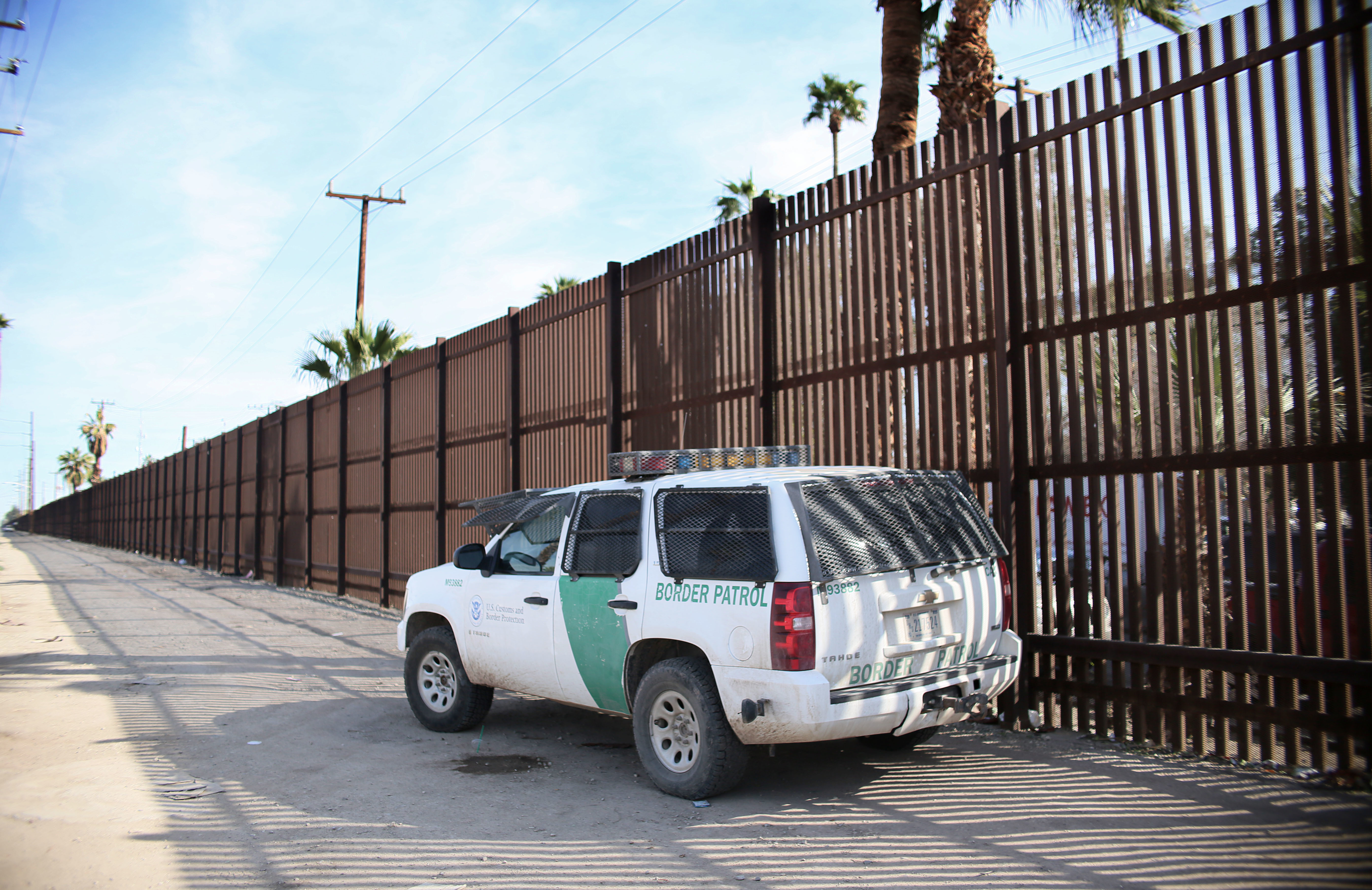 A Border Patrol agent looks over the U.S.-Mexico border wall in Calexico, Calif., on Jan. 31. Apprehensions at the southern border fell dramatically: from more than 40,000 per month late last year to 18,754 in February, and just 12,193 in March. (AFP/Getty Images)