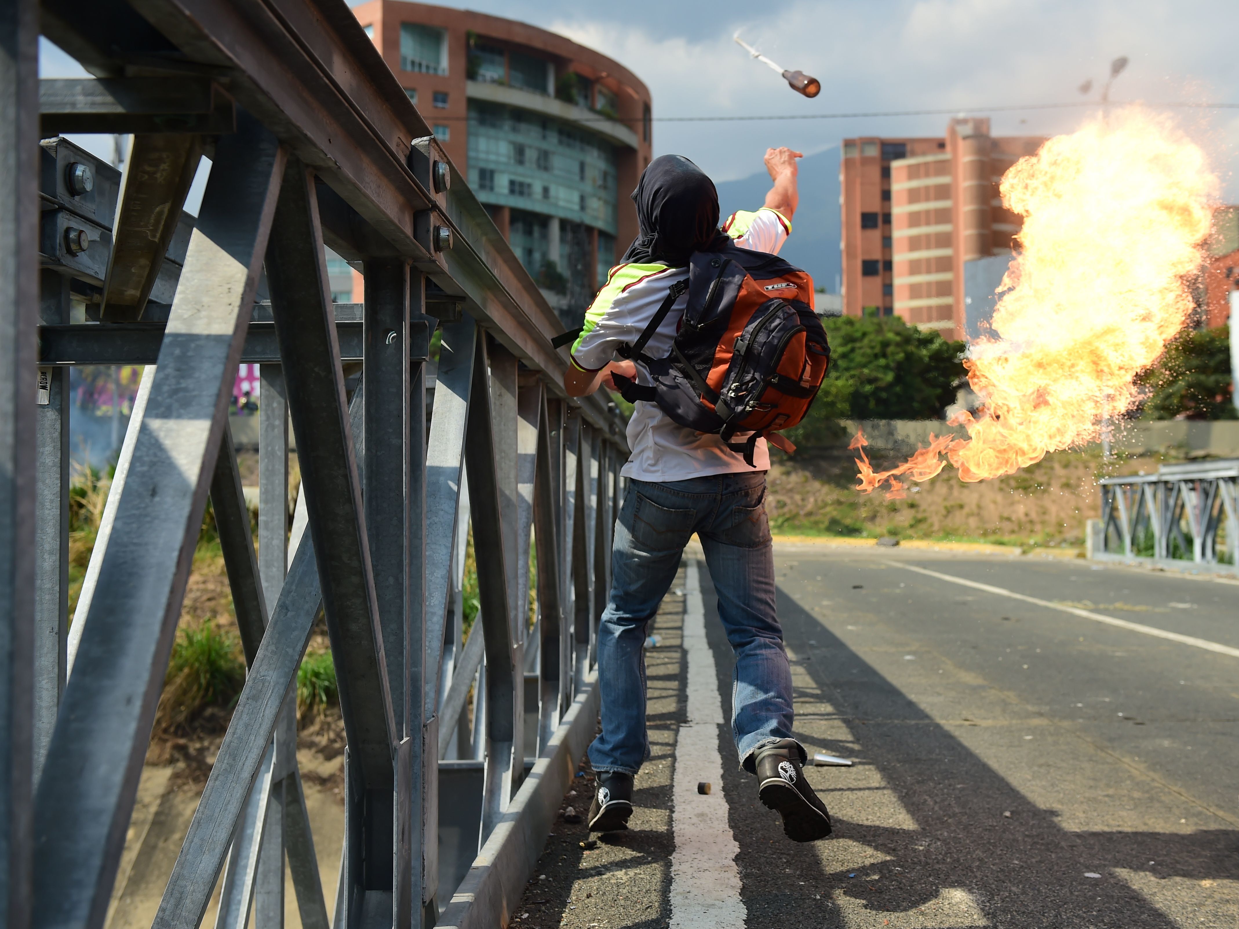 A protester tosses a combustible device during a clash with riot police in Caracas on Wednesday.