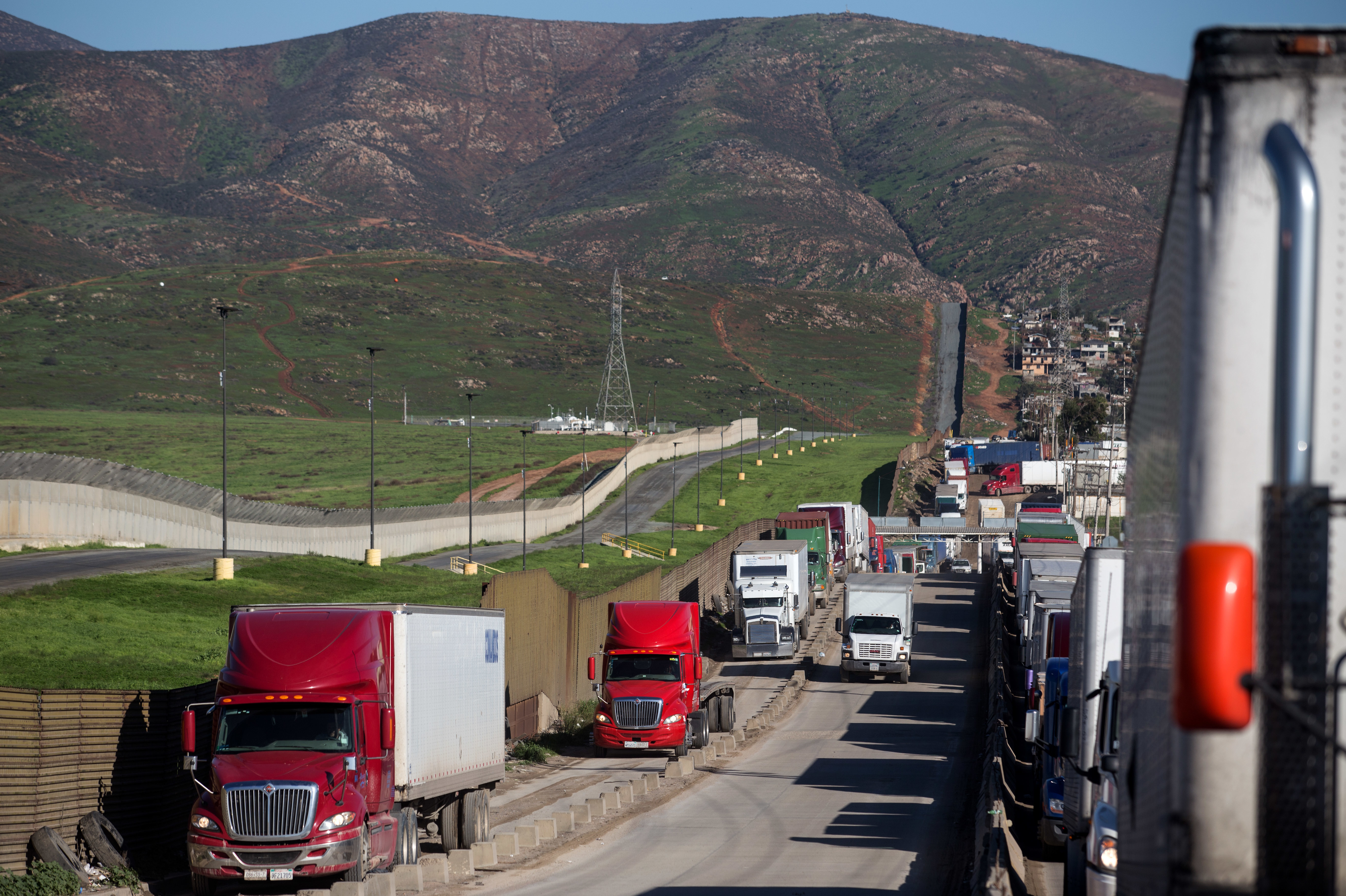 Trucks line up to cross to the United States near the Otay Commercial port of entry on the Mexican side of the U.S.-Mexico border on Jan. 25. Trump now says he will renegotiate the North American Free Trade Agreement, which he has long criticized, rather than scrap it. (AFP/Getty Images)