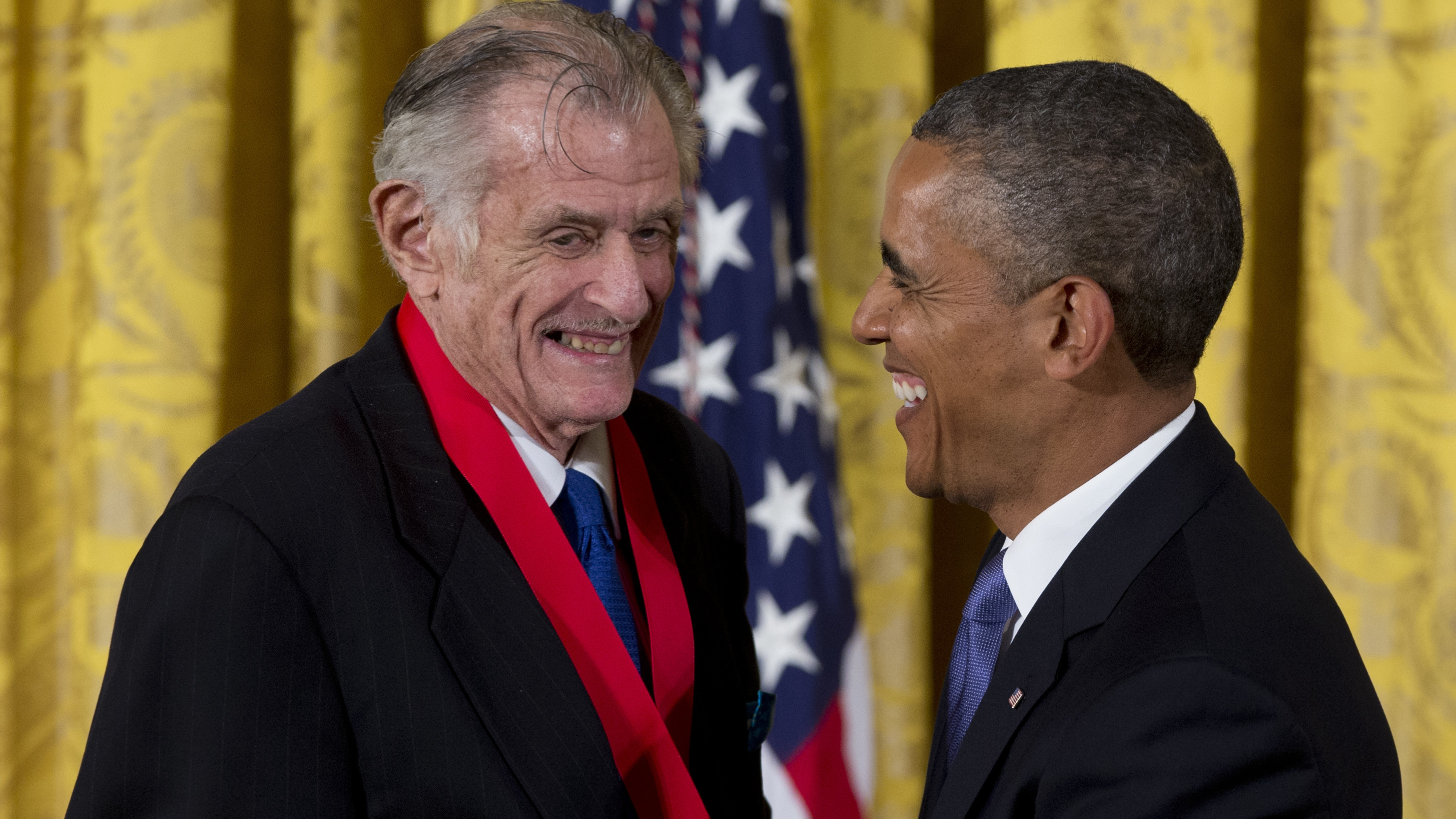 President Barack Obama laughs with Frank Deford as he awards him the 2012 National Humanities Medal for transforming how we think about sports, during a ceremony in the East Room of White House on July 10, 2013.