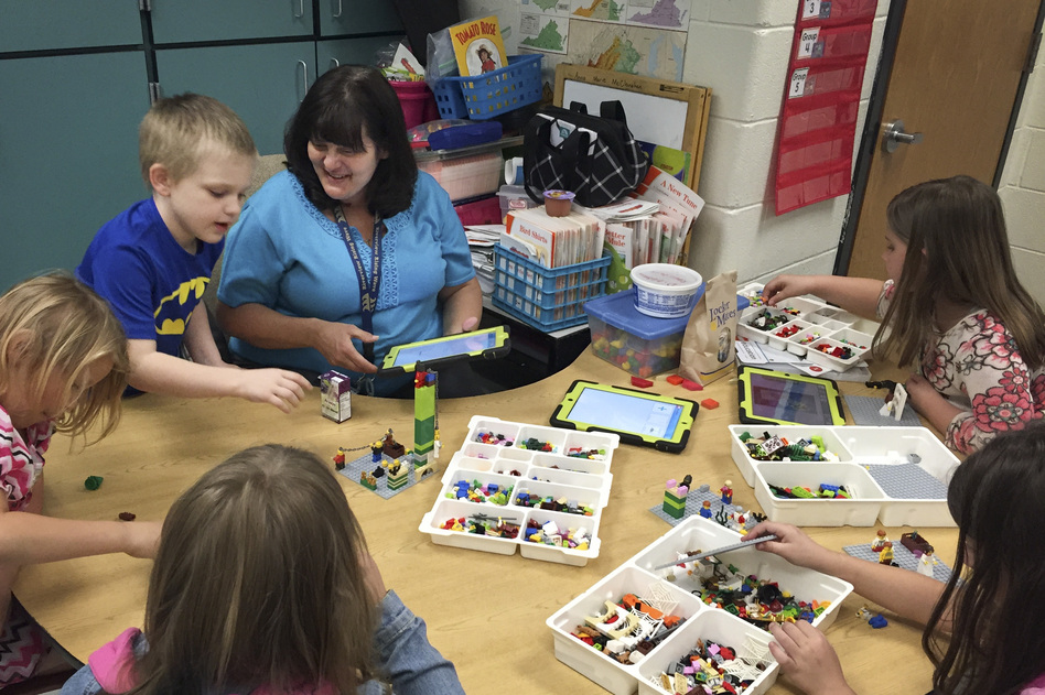 Anna Marie McClanahan (center) helps children write stories by using Legos to create scenes. (Pam Fessler/NPR)