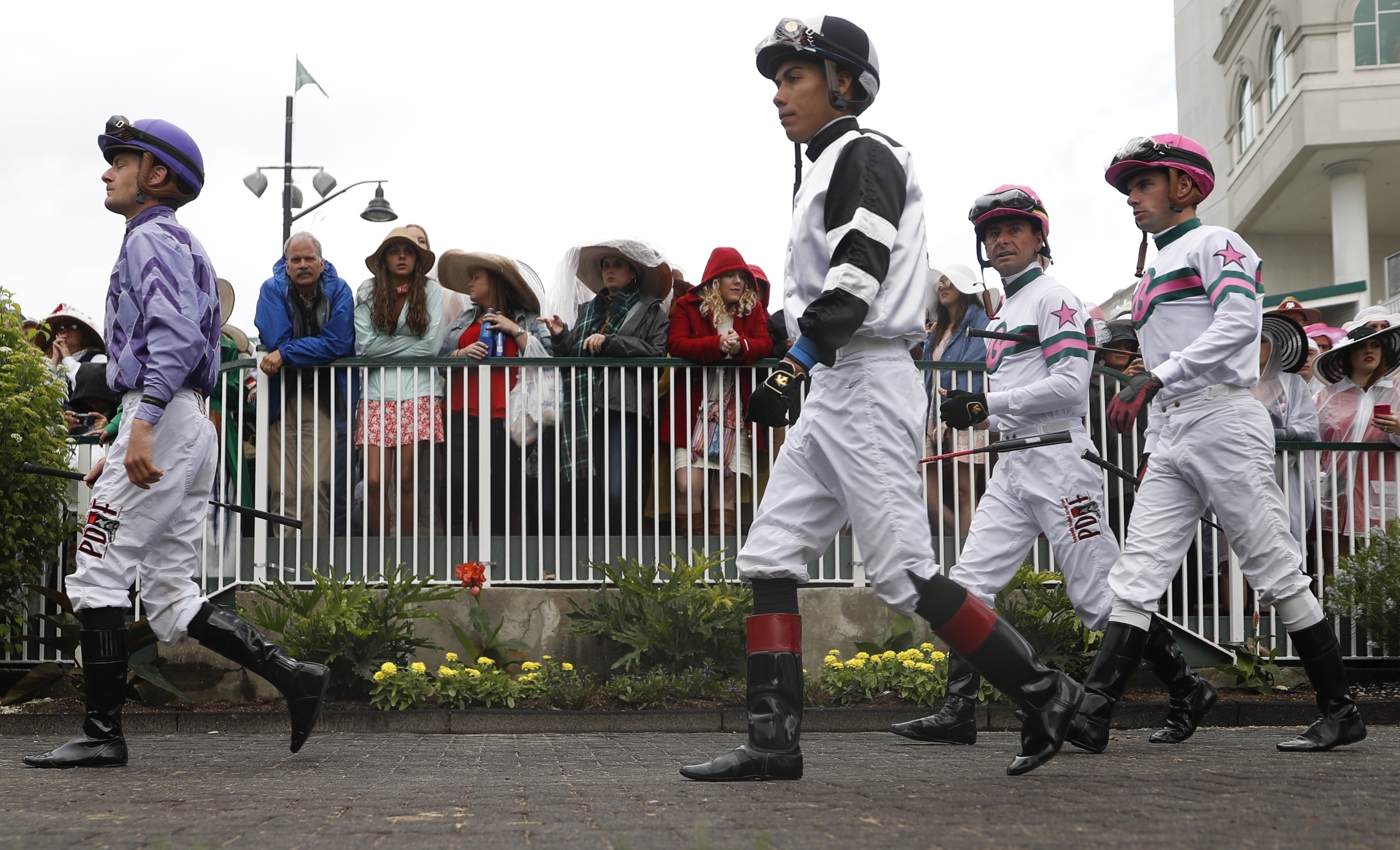 Jockeys walk through the paddock in a race before the 143rd running of the Kentucky Derby horse race at Churchill Downs Saturday.