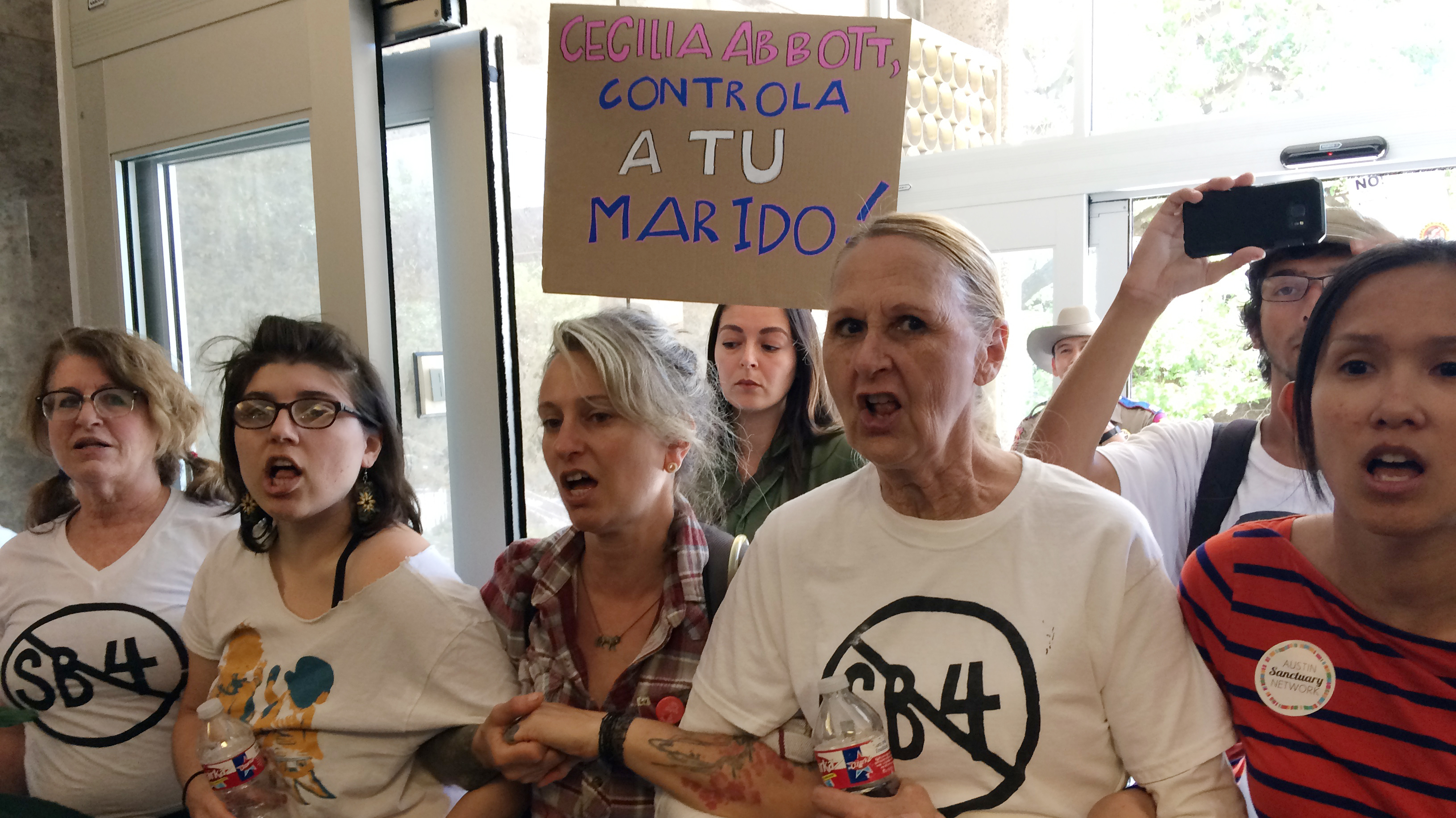 Protesters rally during a sit-in at the Texas Department of Insurance building in Austin last week. They oppose the bill that Gov. Greg Abbott signed into law Sunday. It compels police to enforce federal immigration laws.