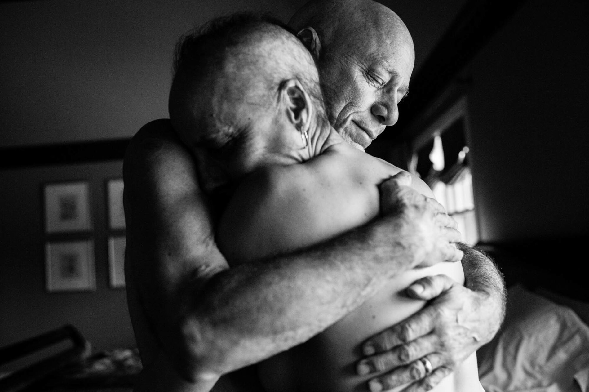 Dad and Mom embrace in the bedroom of their home. They never could have imagined both being in treatment for cancer at the same time. Together, they faced the daily struggles of illness in their own lives while also caring for each other.
(Nancy Borowick)