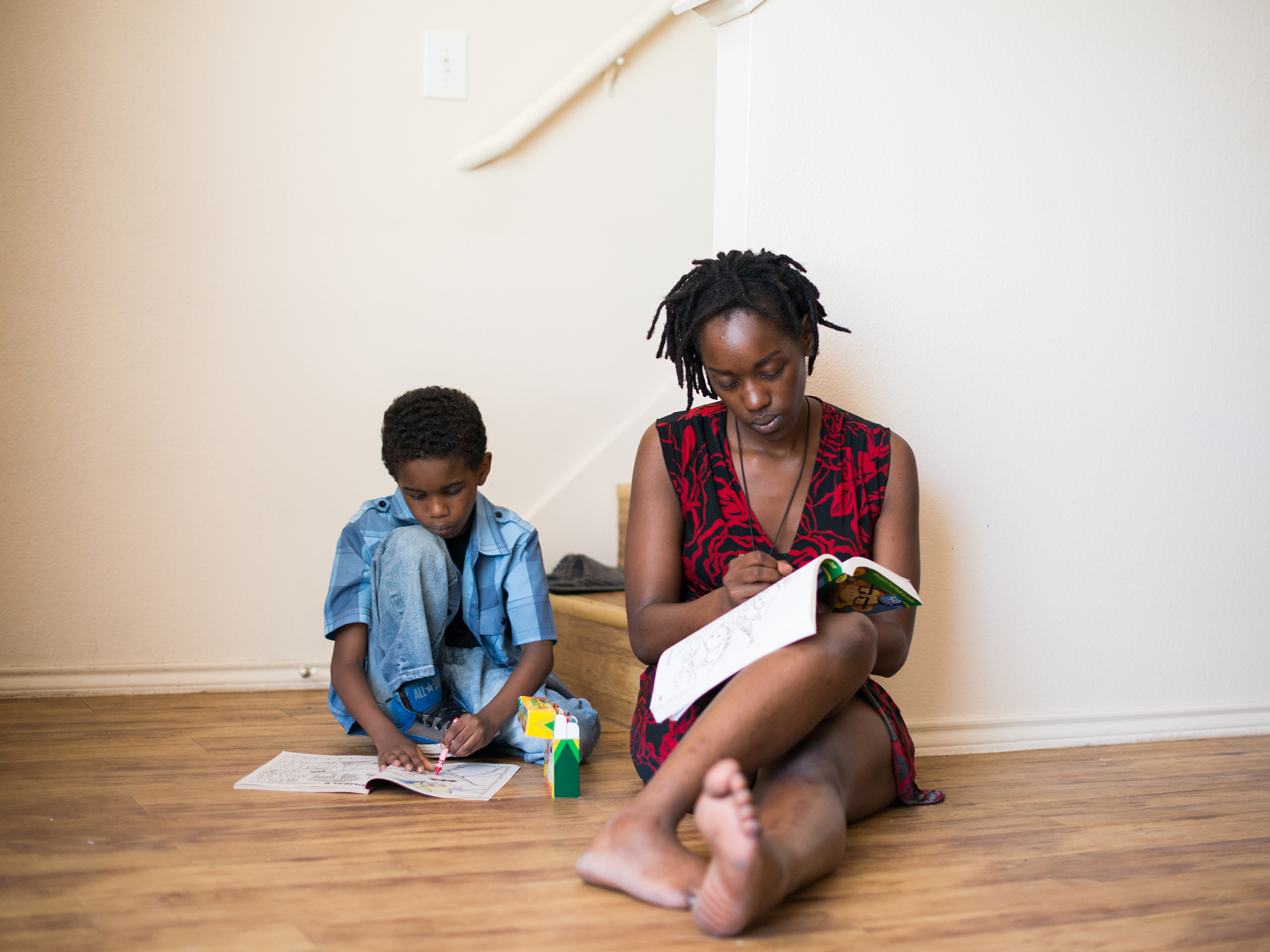 Farryn Giles colors with her son Isaiah at their apartment in Dallas. (Brandon Thibodeaux for NPR)