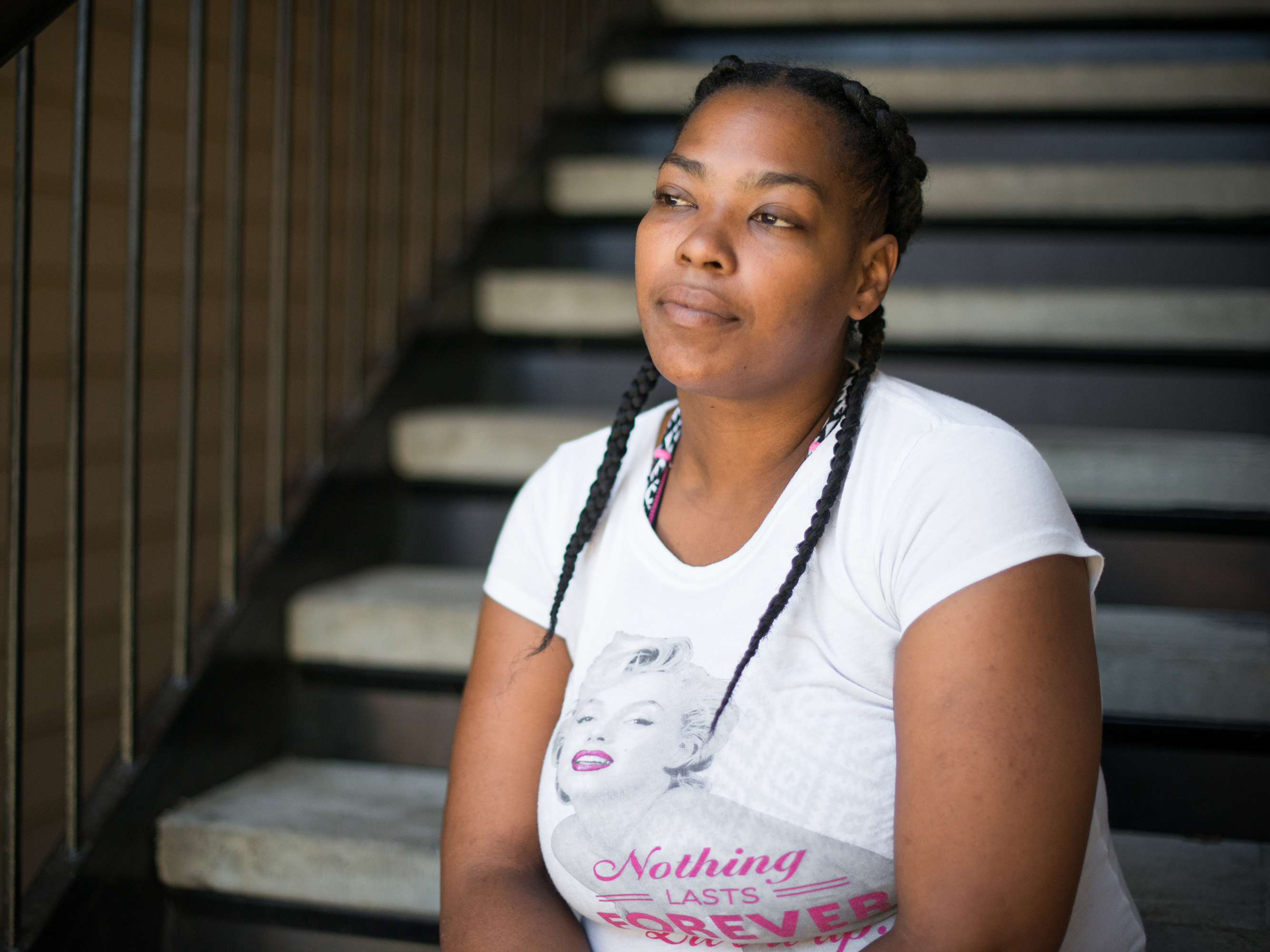 C'Artis Harris, 34, sits outside a friend's apartment where she and her children are staying until she finds available housing in Dallas. (Brandon Thibodeaux for NPR)