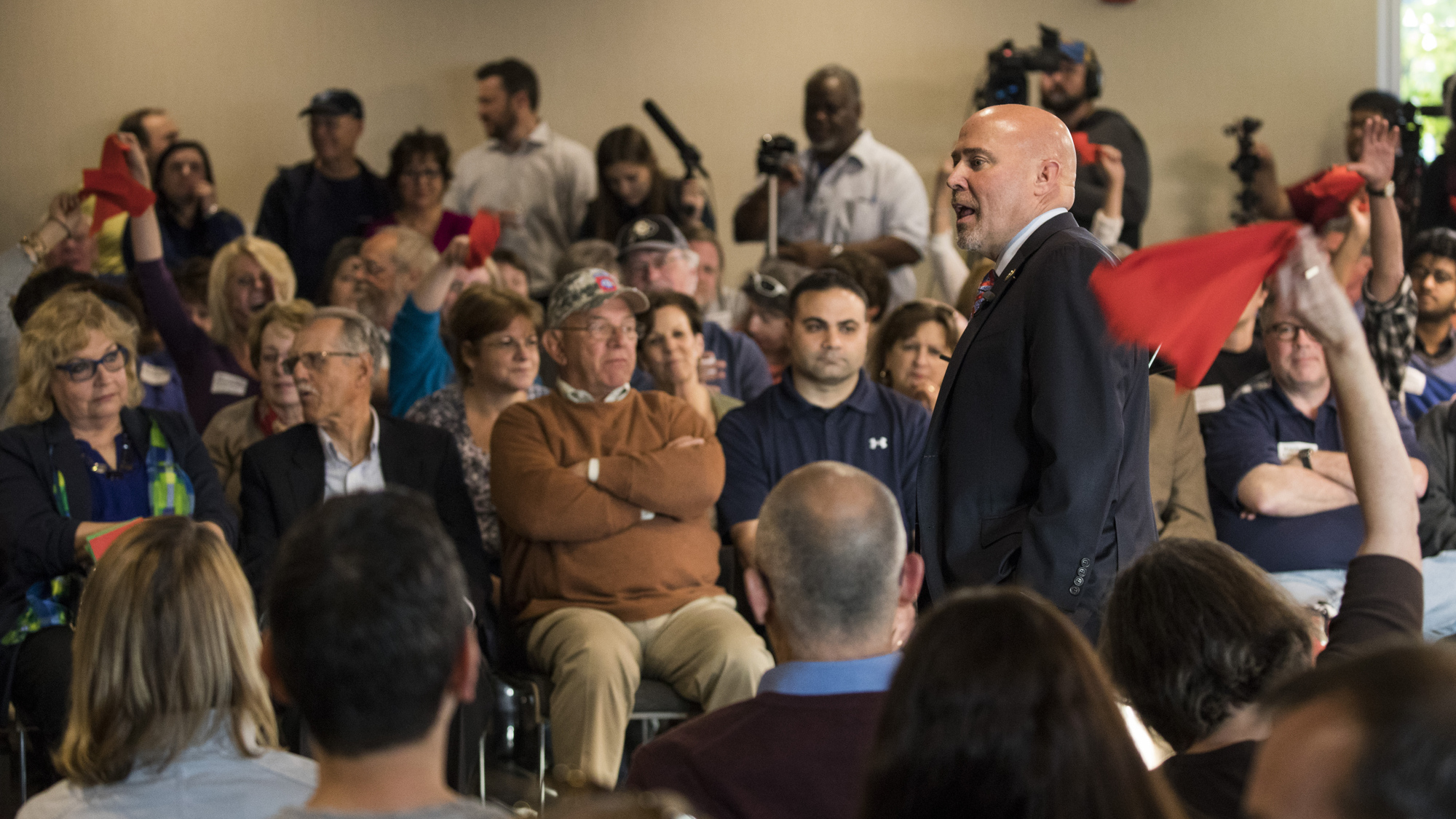 Audience members wave red flags in response to Rep. Tom MacArthur, R-N.J., at a raucous town hall Wednesday night in Willingboro. (AFP/Getty Images)