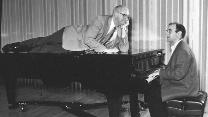 Kasell decides to take a publicity photo shoot up a notch while Wait Wait... Don't Tell Me! host Peter Sagal tickles the ivories. (Wait Wait... Don't Tell Me!/NPR)
