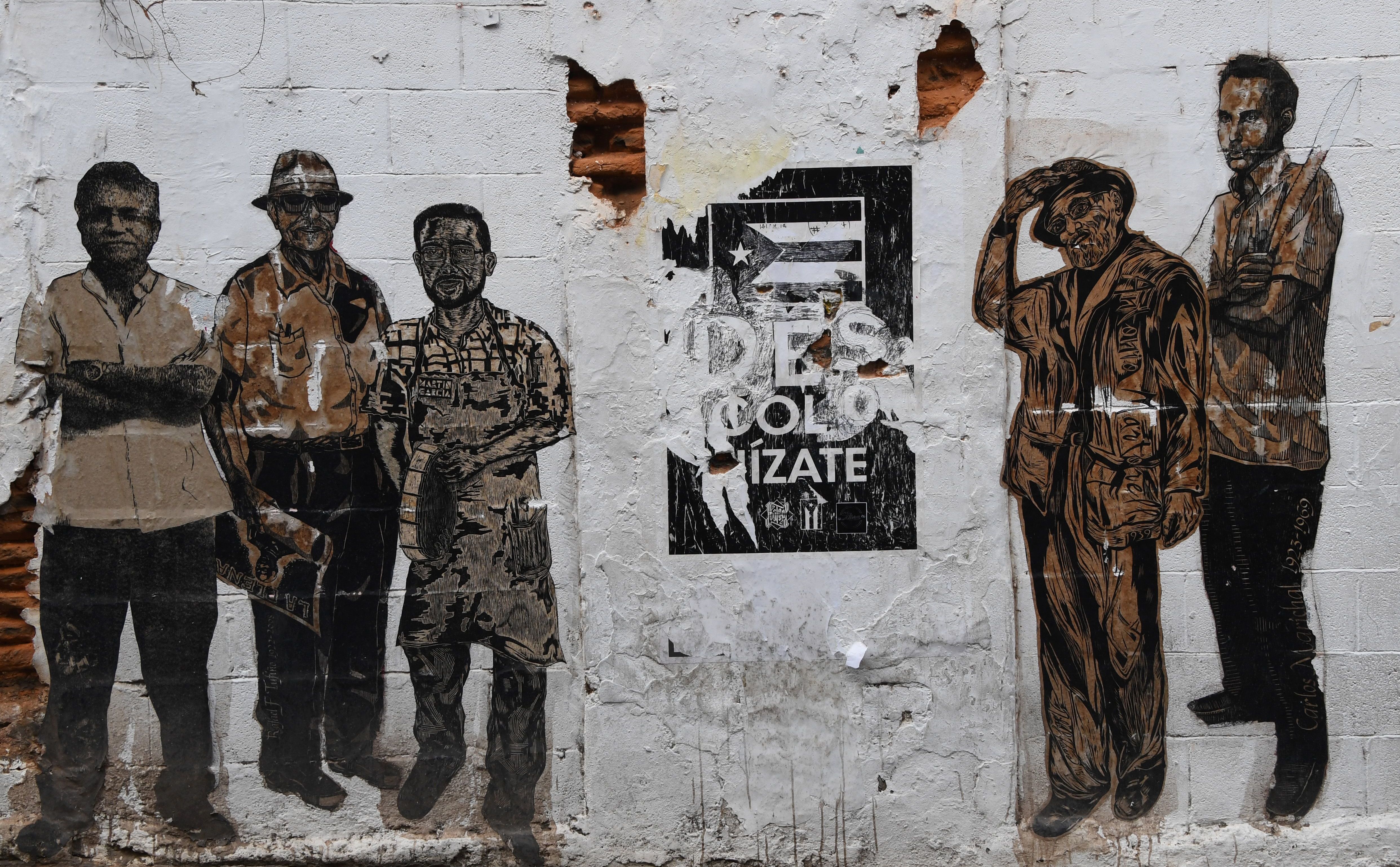 A mural displays notable historical figures and a fading Puerto Rican flag on a dilapidated building in San Juan earlier this month. Between its public-sector debt and money owed pension funds, the U.S. territory is grappling with more than $120 billion in debt. (AFP/Getty Images)