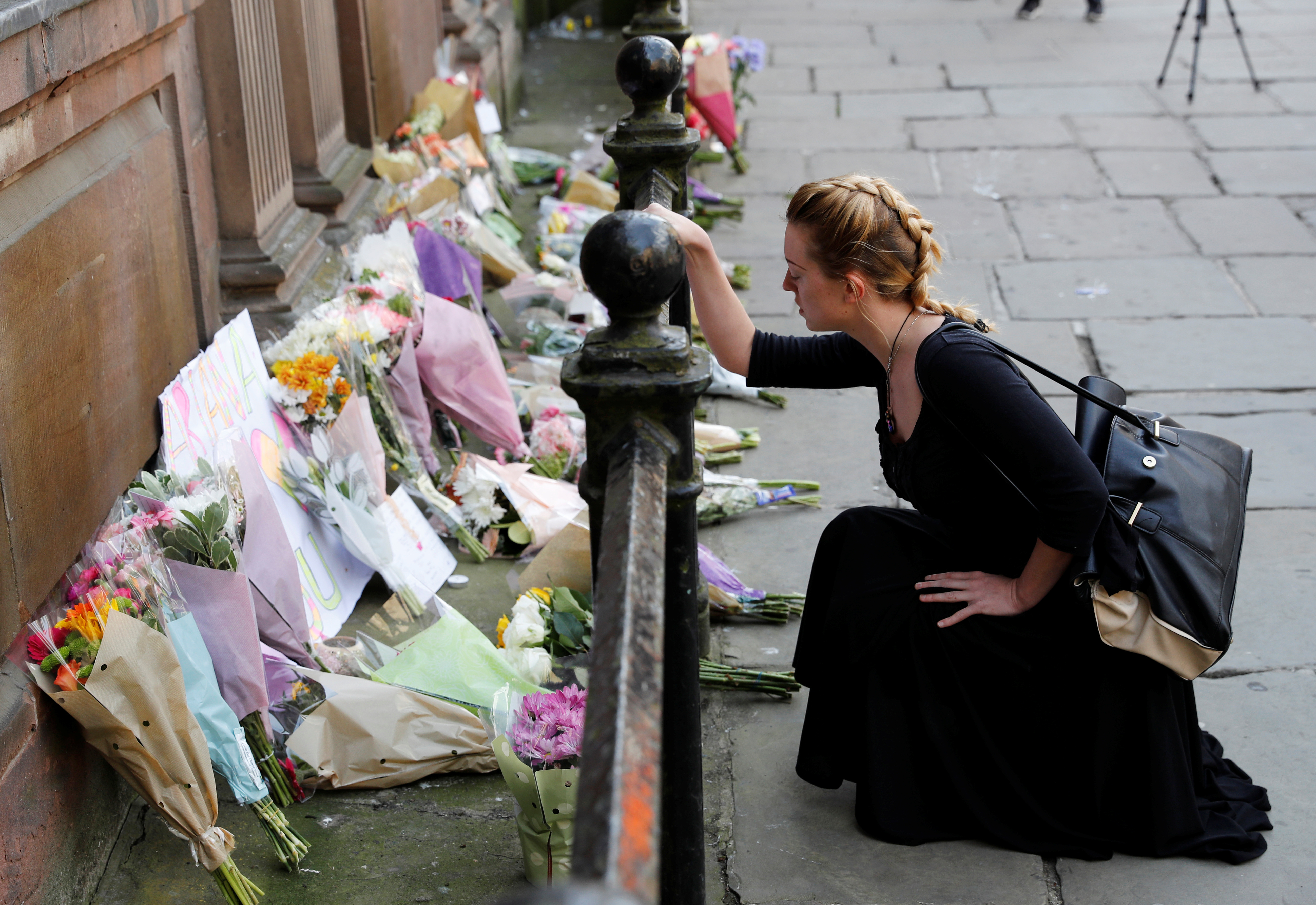 A woman lays flowers for the victims of the Manchester Arena attack in central Manchester, England, on Tuesday. (Reuters)