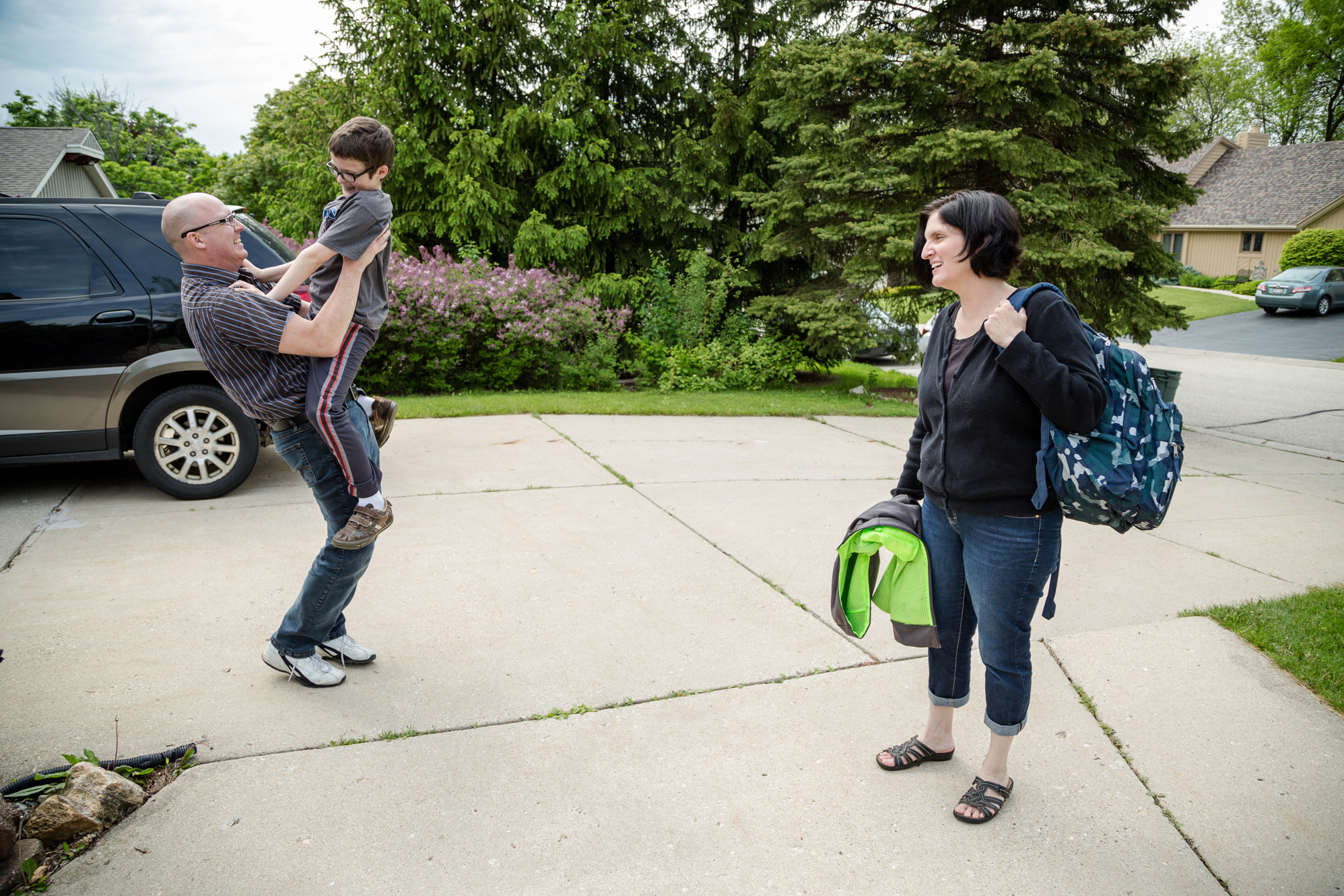 Ben Gapinski, 10, (center) is greeted by his parents Dan and Nancy Gapinski after getting off the school bus. When Ben was a toddler, he was diagnosed with an autism spectrum disorder and needed constant monitoring to stay safe. (Sara Stathas for NPR)