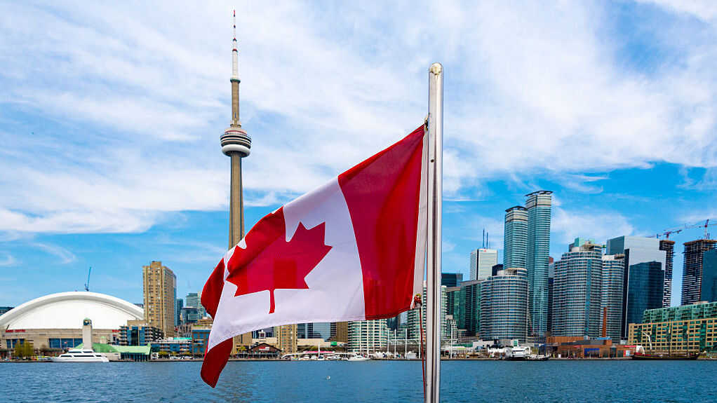 Canadian flag and the Toronto skyline.