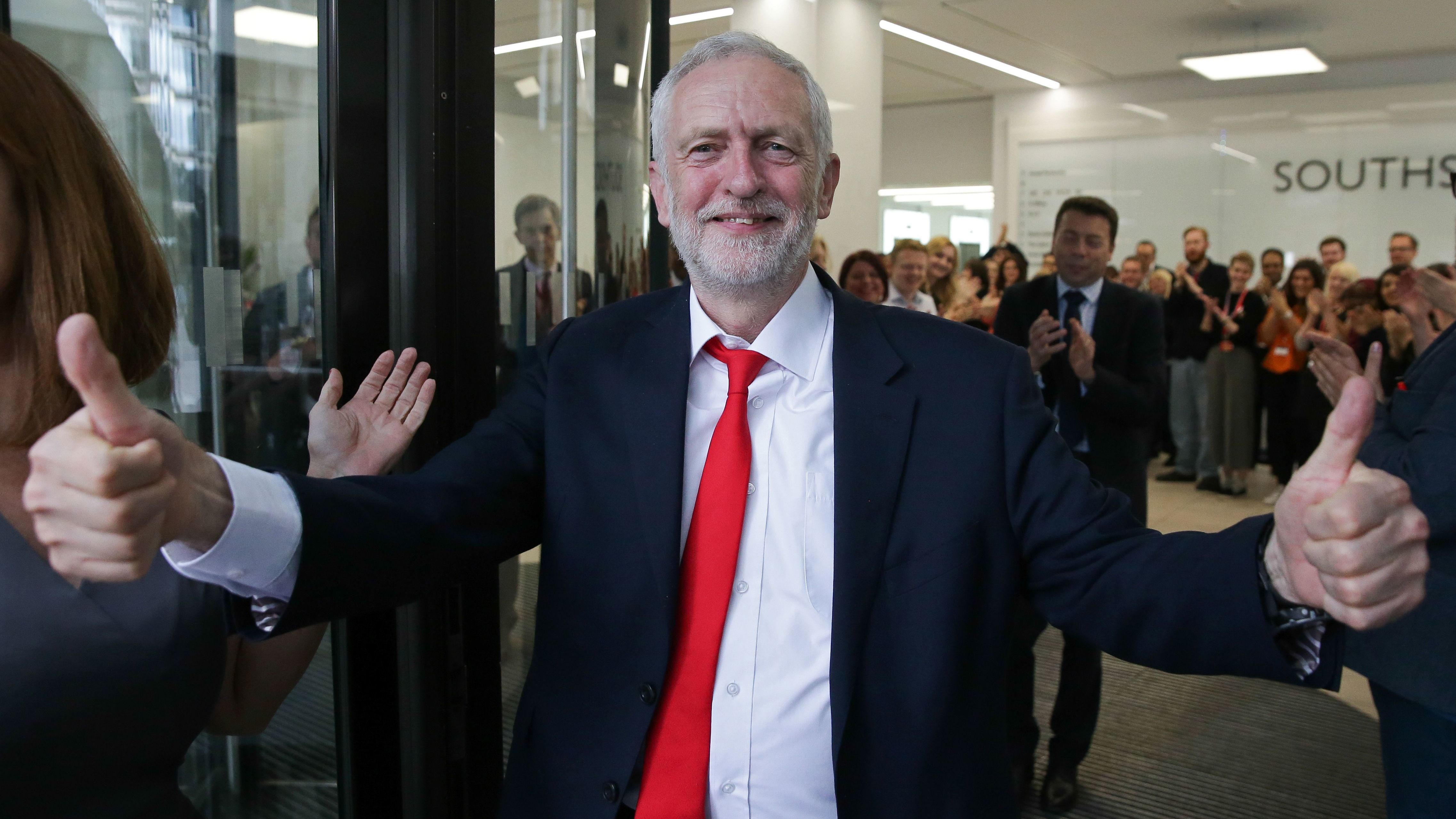 Labour leader Jeremy Corbyn gives a thumbs up as he arrives at the party's headquarters in London on Friday. Corbyn says he's prepared to keep up the pressure as Theresa May works to form a new government in the U.K.