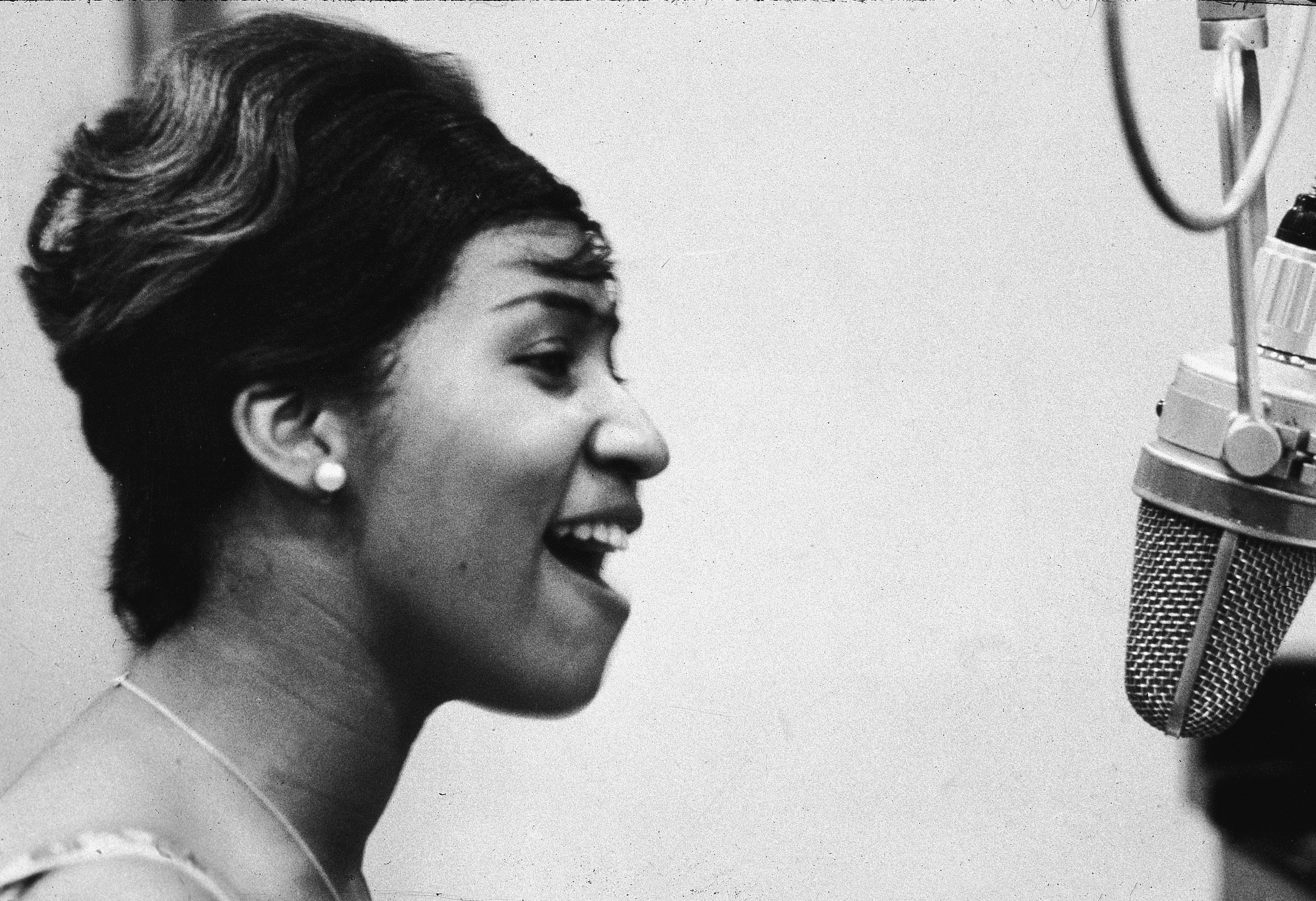 Aretha Franklin sings in the studio during during her early career at Columbia Records. (Getty Images)