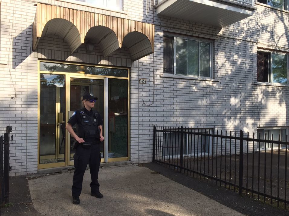 A police officer in Montreal guards the front of an apartment building, where Amor Ftouhi lived before traveling to the U.S. earlier this month. Ftouhi, a Canadian resident, is suspected of stabbing an airport police officer in Flint, Mich., on Wednesday. The FBI said it is investigating it as an "act of terrorism."