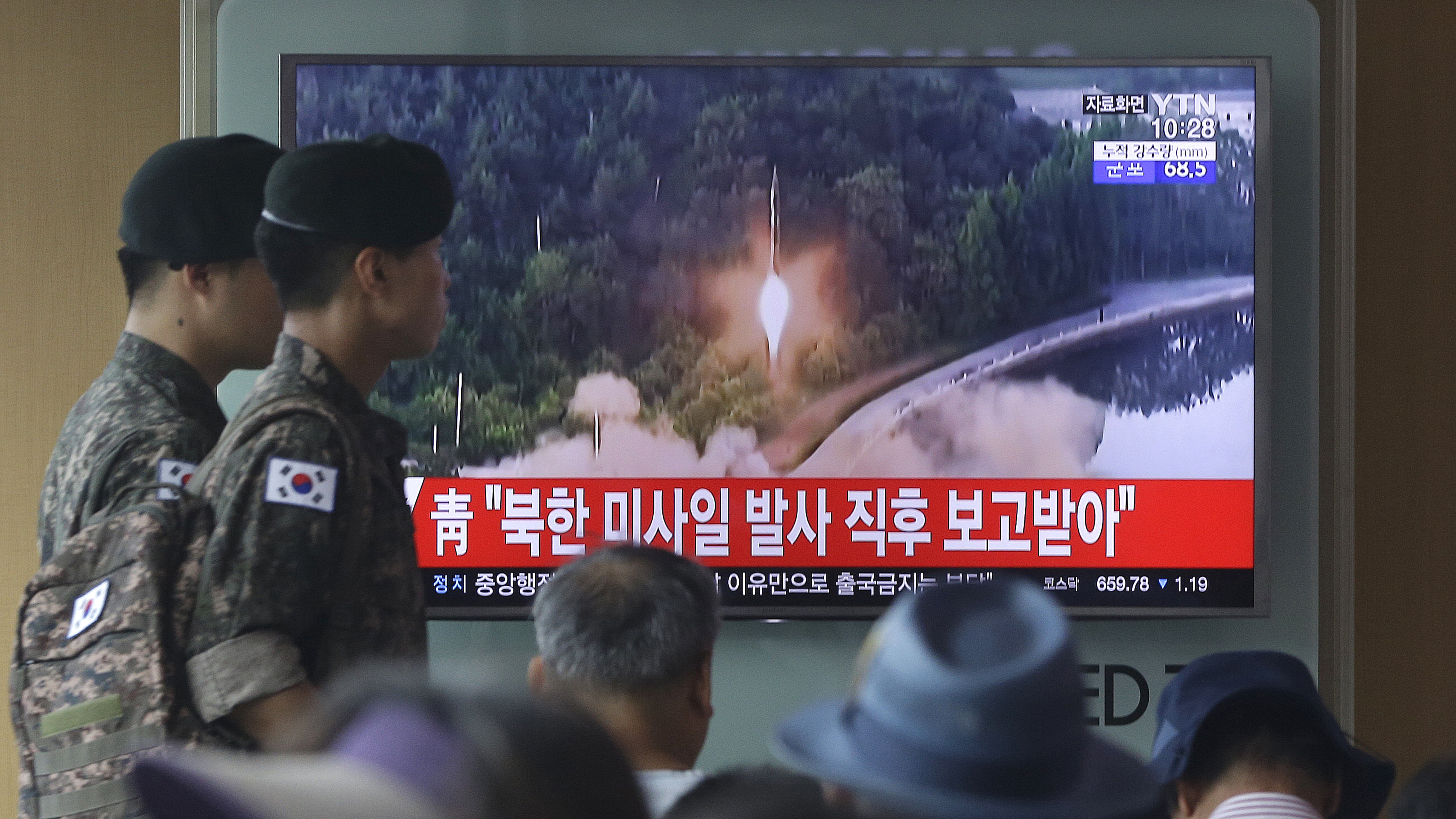 South Korean soldiers in Seoul walk by a TV news program showing a file image of a missile being test-launched. North Korea on Tuesday test-launched another ballistic missile in the direction of Japan, U.S. and South Korean officials said.