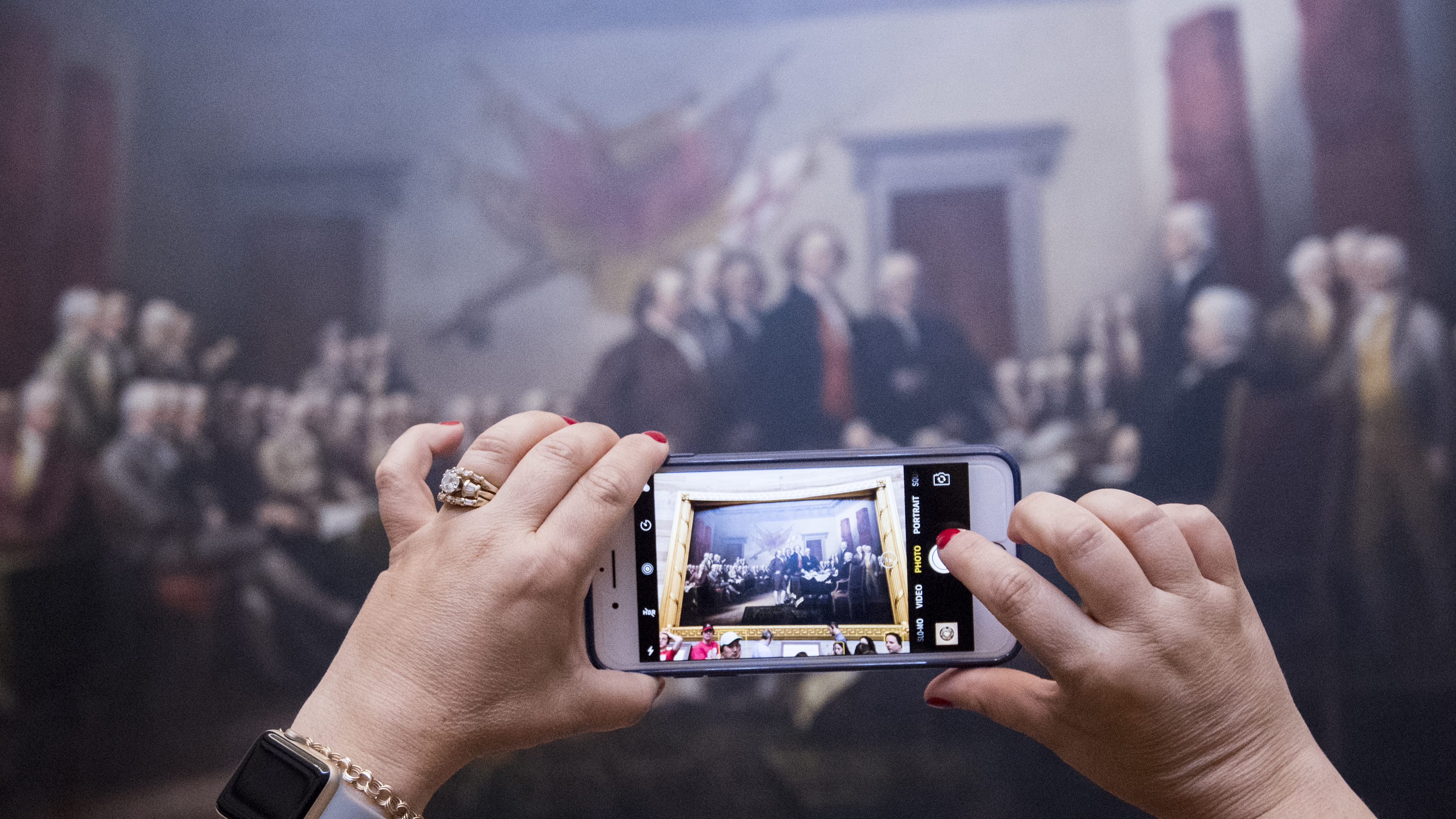 A tourist takes a photo of John Trumbull's Declaration of Independence painting in the Capitol Rotunda on June 28, 2017. (CQ-Roll Call,Inc.)