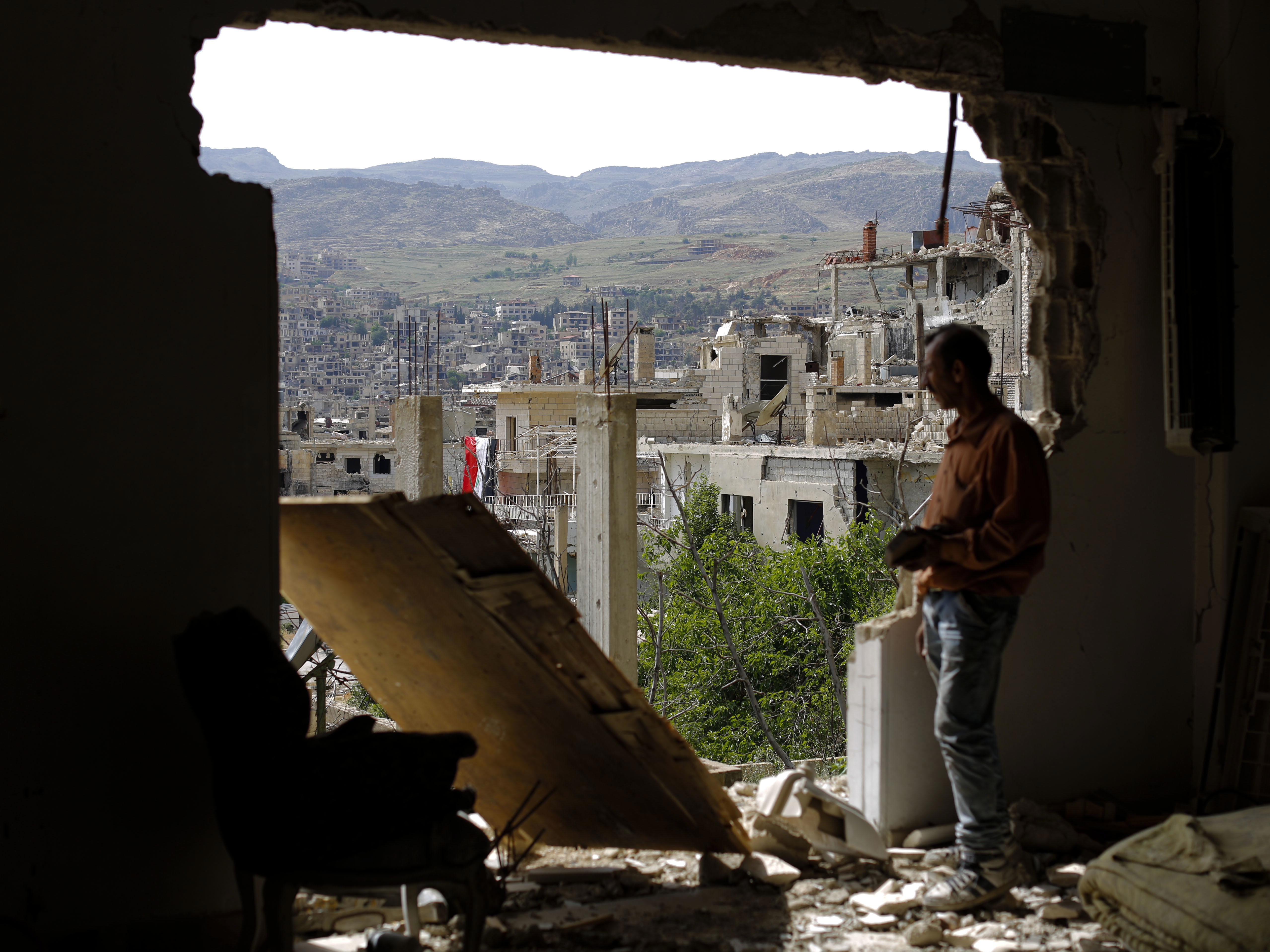 A man looks out of a damaged building in the mountain resort town of Zabadani, Syria, in the Damascus countryside, in May. The U.S. and Russia announced a new cease-fire deal on Friday.