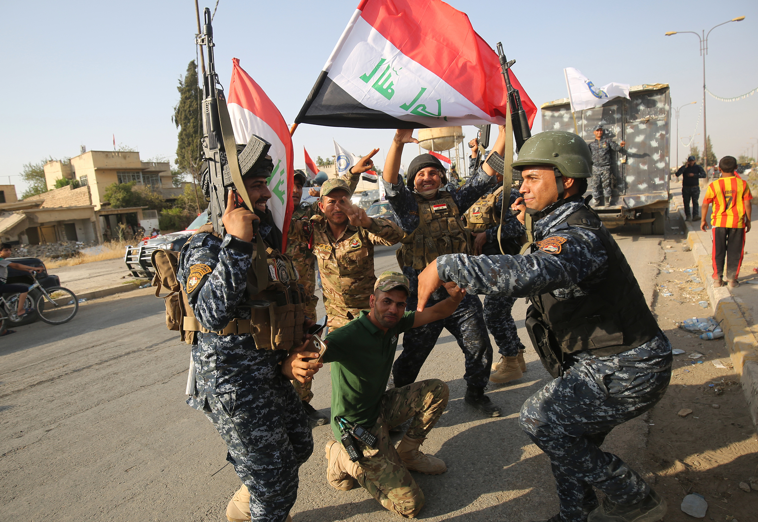 Iraqi federal police members celebrate in the Old City of Mosul on Sunday, after Iraqi Prime Minister Haider al-Abadi's office said he was in "liberated" Mosul to congratulate "the heroic fighters and the Iraqi people on the achievement of the major victory."