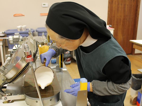 Benedictine Sister of Perpetual Adoration Marie Jona Yoo pours batter on a hot plate used to bake low-gluten altar breads.