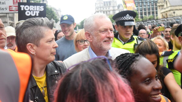 Labour leader Jeremy Corbyn is mobbed by young supporters after addressing an anti-austerity rally in Parliament Square, London, following a march through the city on July 1.