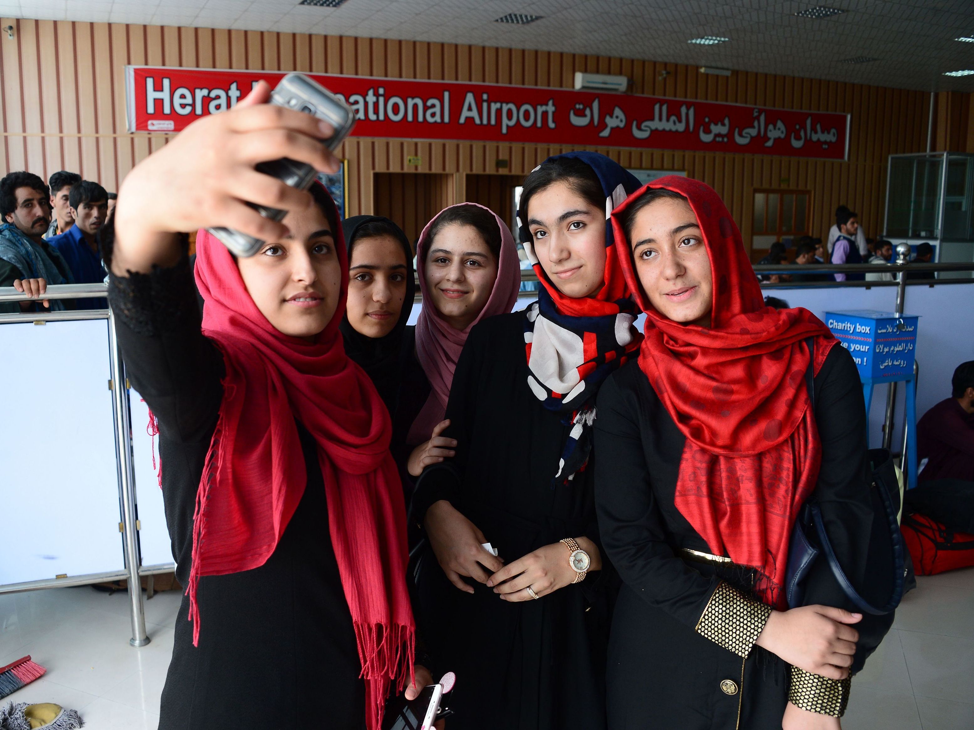 After twice being denied visas, a team of Afghan girls, who stopped for a photo at Herat International Airport in western Afghanistan on Thursday, has been permitted to travel to the U.S. for a robotics competition. (AFP/Getty Images)