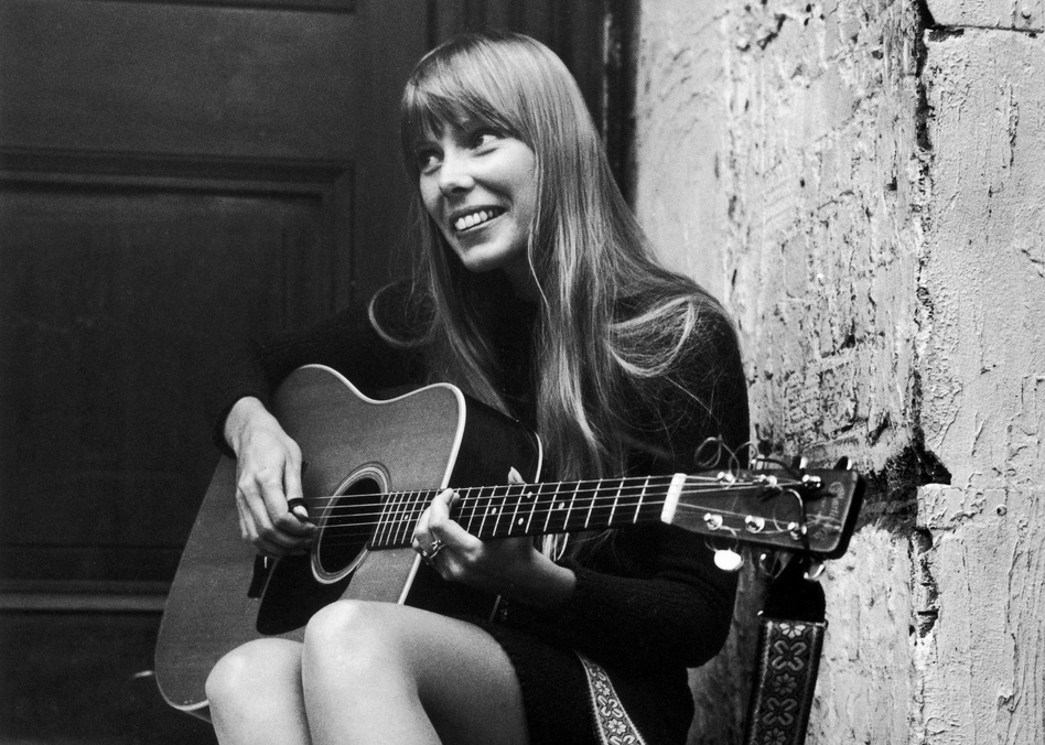 Joni Mitchell strums her guitar outside The Revolution club in London in 1968. (Central Press/Getty Images)