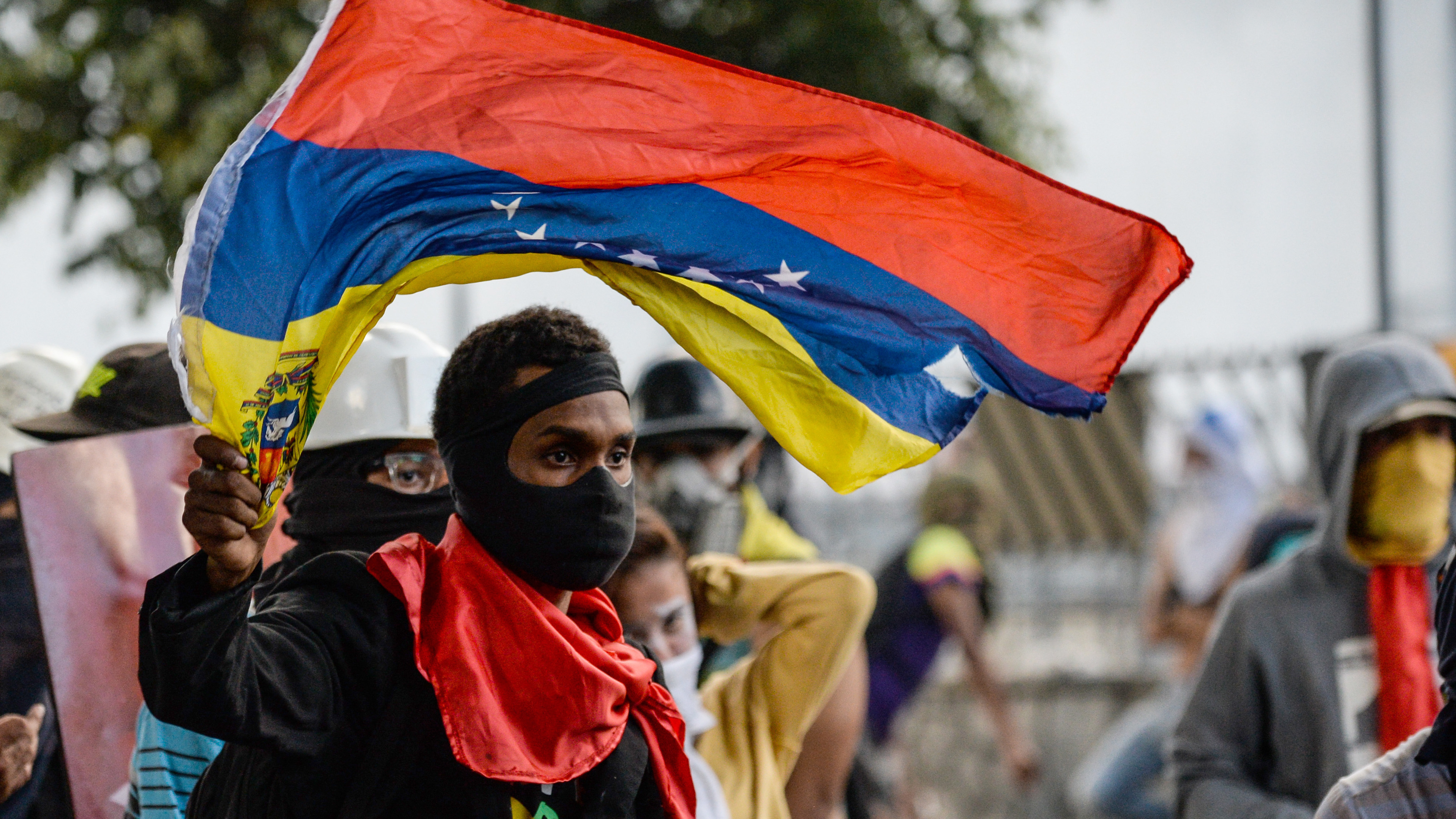 An anti-Maduro demonstrator waves the Venezuelan flag at a protest in the capital, Caracas, on Wednesday. The government banned such demonstrations nationwide for the next five days, as the country approaches a Sunday vote on delegates for Maduro's constituent assembly, which would lead a rewrite of the constitution. (AFP/Getty Images)