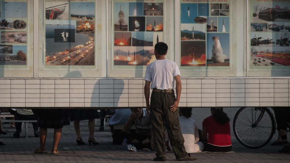 A man looks at images depicting missile launches and military exercises, on a display board in Pyongyang, North Korea, earlier this week.