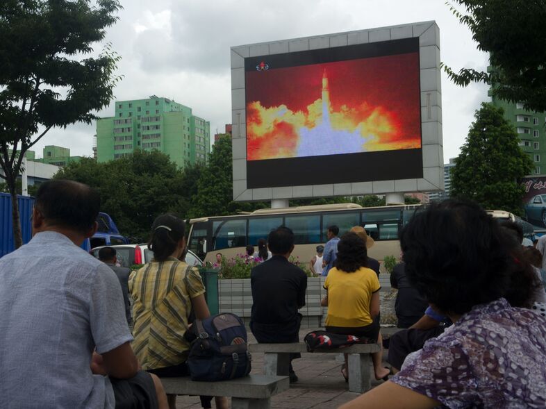 People watch as coverage of an ICBM missile test is displayed on a screen in a public square in Pyongyang on July 29, 2017. (Kim Won-Jin/AFP/Getty Images)