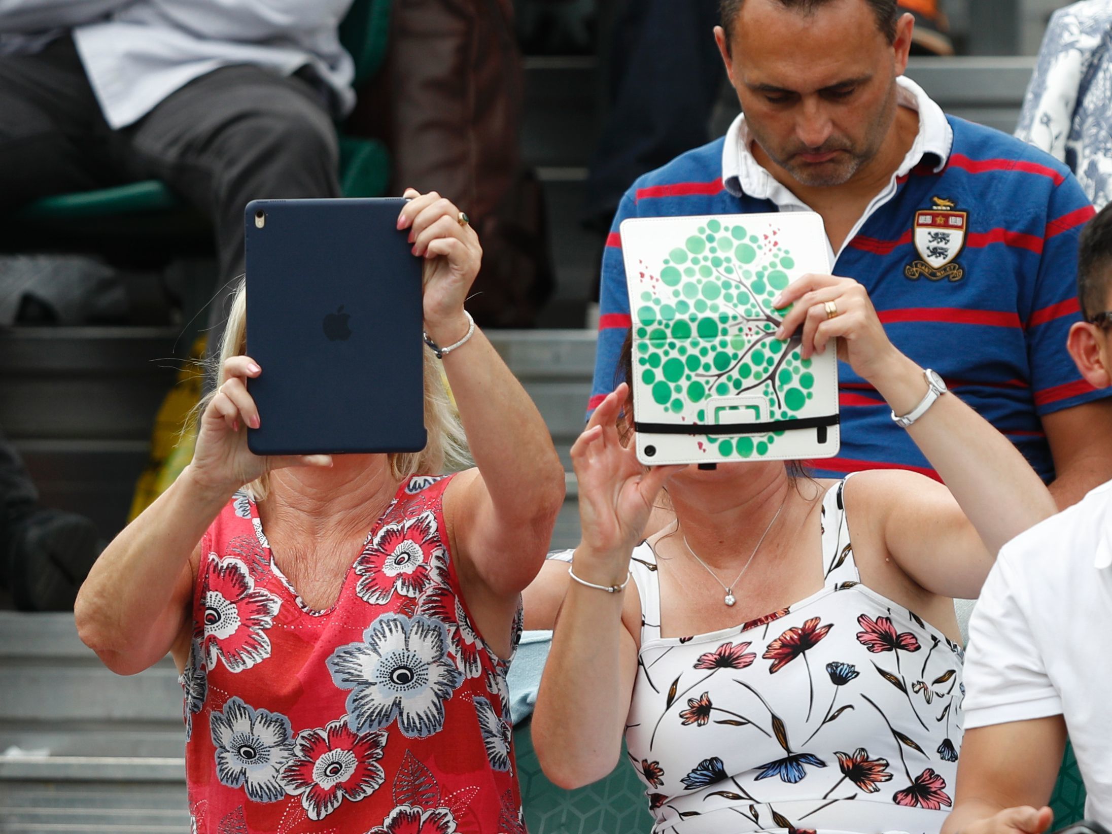 A spectator at Wimbledon last month uses an iPad to take pictures of the action. Improved sales of the tablets were part of the good news out of Apple's quarterly report. (AFP/Getty Images)