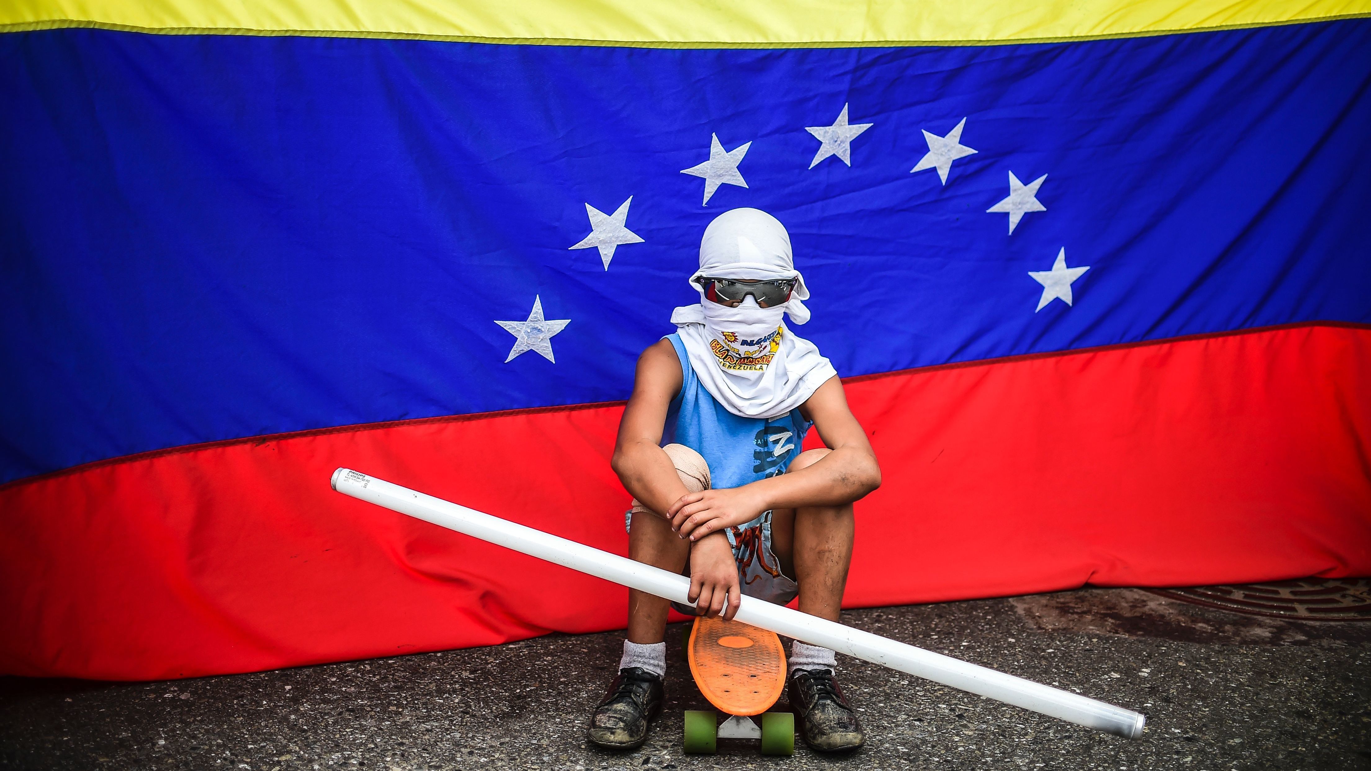 An opposition activist sits in front of a Venezuelan flag during a protest against the constituent assembly in Caracas last week. Opponents of President Nicolas Maduro have struggled to find a foothold in their struggle against his consolidation of power. (AFP/Getty Images)